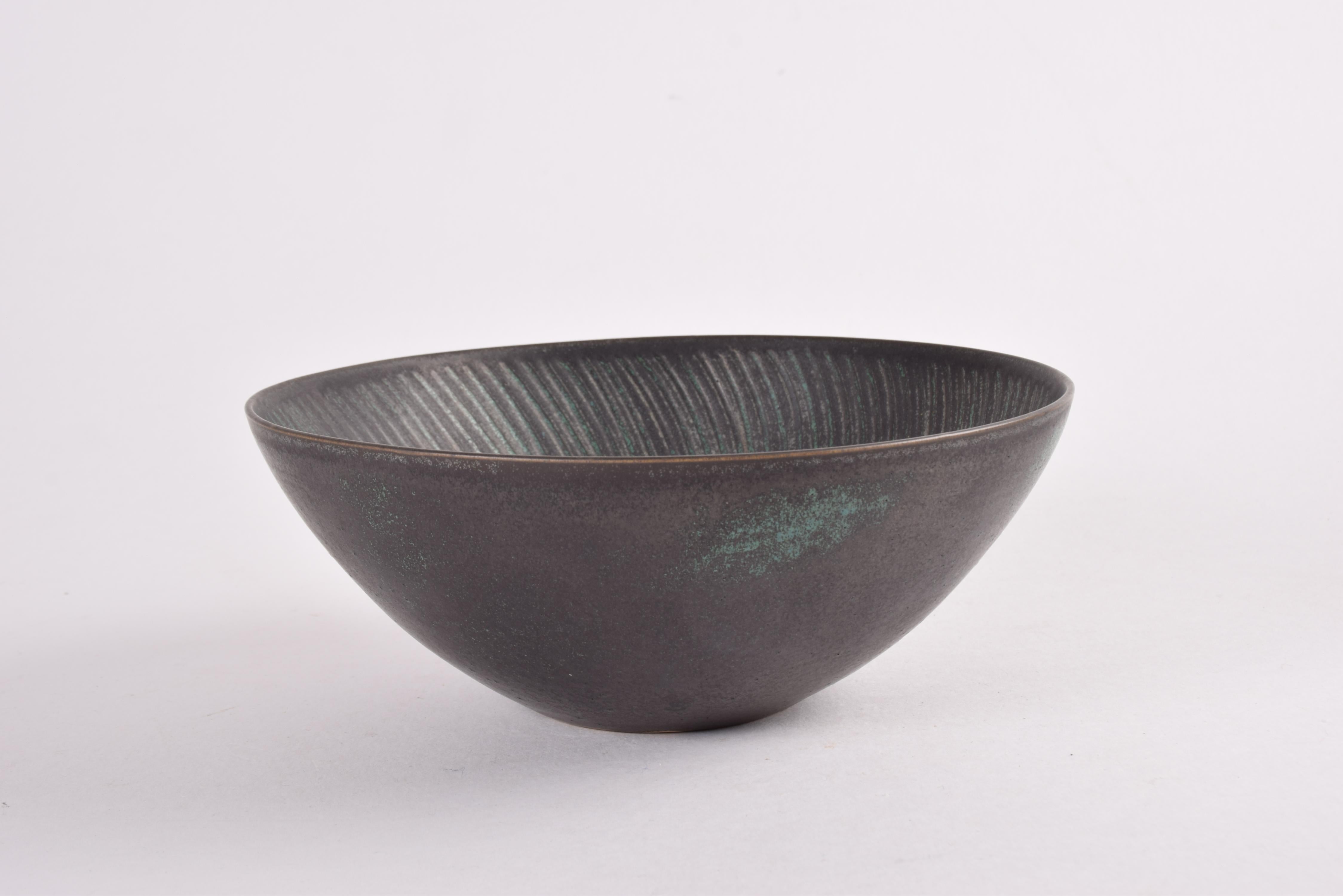 Ciotola vintage originale del designer svedese Stig Lindberg per l'esclusivo laboratorio Studiohanden di Gustavsberg. Prodotto circa negli anni '60. 

La ciotola presenta uno smalto grigio scuro, quasi nero, con elementi di colore blu turchese e