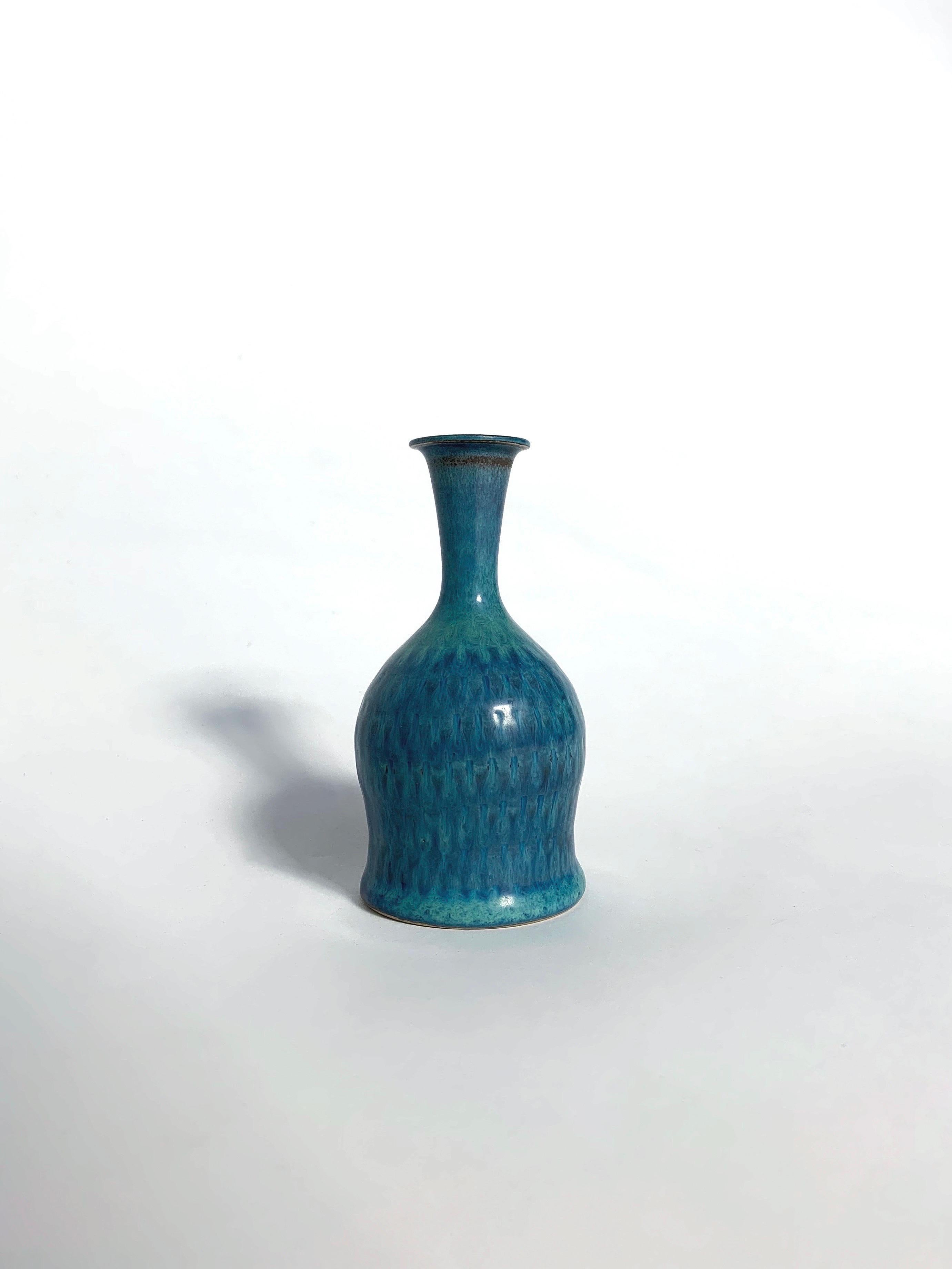 Vaso unico di Stig Lindberg con uno splendido smalto blu turchese, realizzato a mano per Gustavsberg in Svezia nel 1963.

Gres prodotto a mano con un motivo impresso, sovrasmaltato. Firmato con la firma dell'artista nel 1963.

Altezza: 11.5