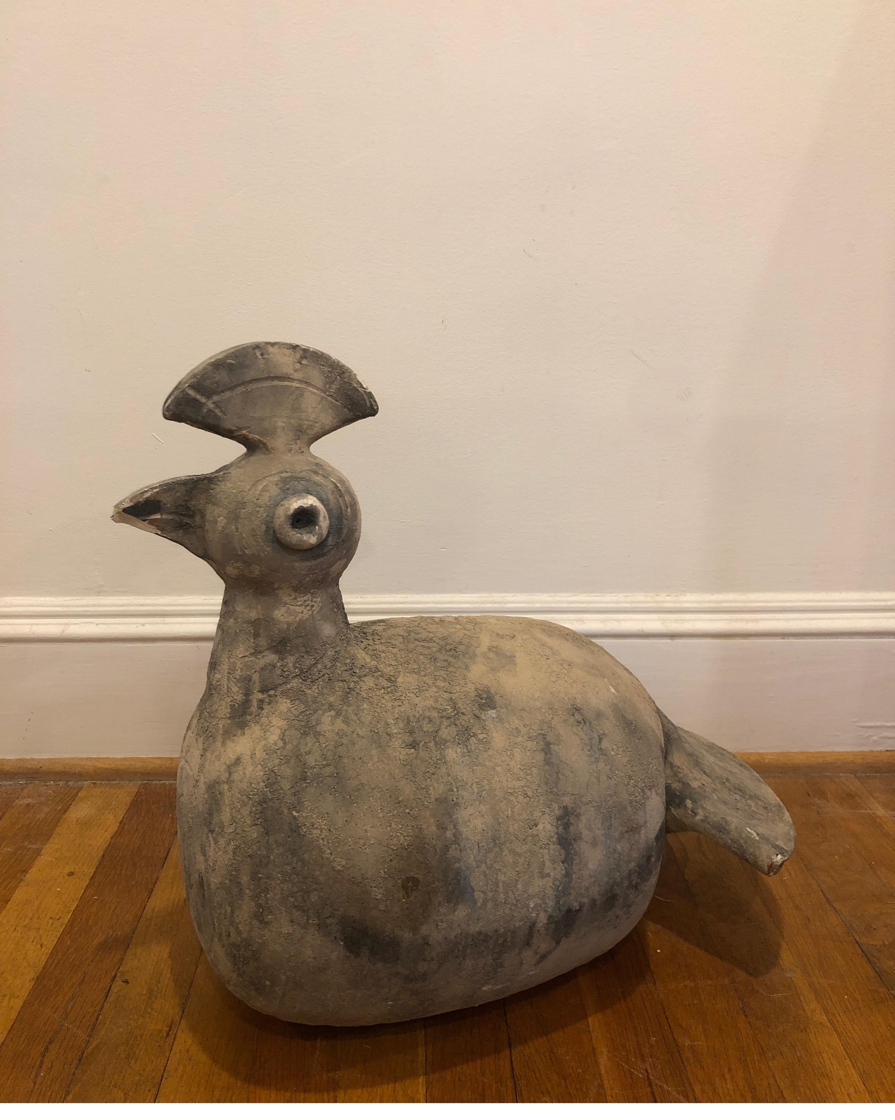 Unsigned unique piece. Very eye-catching.
Stone archaic bird sculpture.
Constructed of interesting angles around the eyes and the crown. 
The overall look is earthy tribal. 
Measures 20 L x 12 W x 18.5 H


Please note there is a chip on his