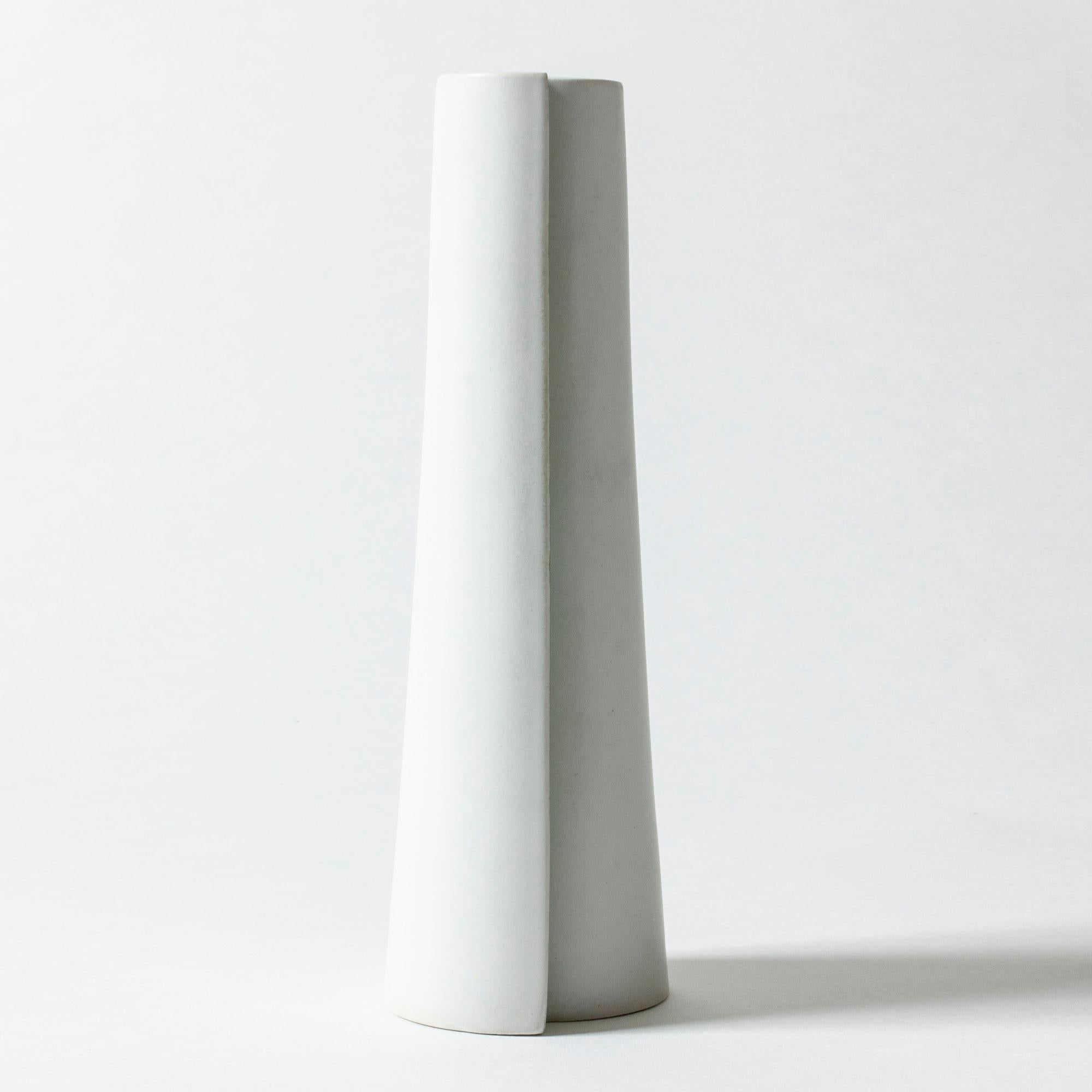Unique Carrara stoneware “Surrea” vase by Wilhelm Kåge, in a sleek design. The skewed form is made from two sections, that create an expressive shadow play. Painted light green on both sides.