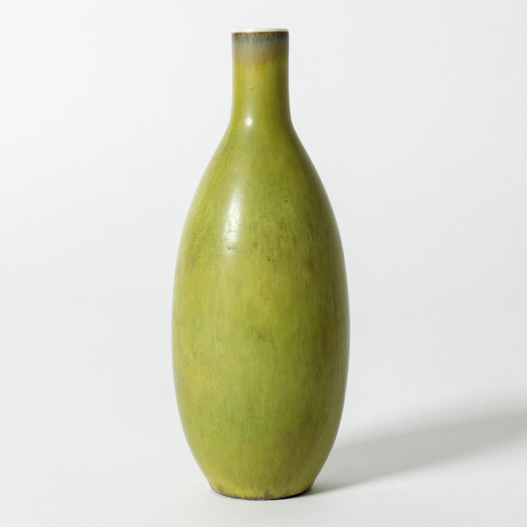 Unique stoneware vase by Carl-Harry Stålhane, in a clean, graphic form. Vibrant papaya green glaze, with a white ring around the rim of the neck.

Carl-Harry Stålhane was one of the stars among Swedish ceramic artists during the 1950s, 1960s and