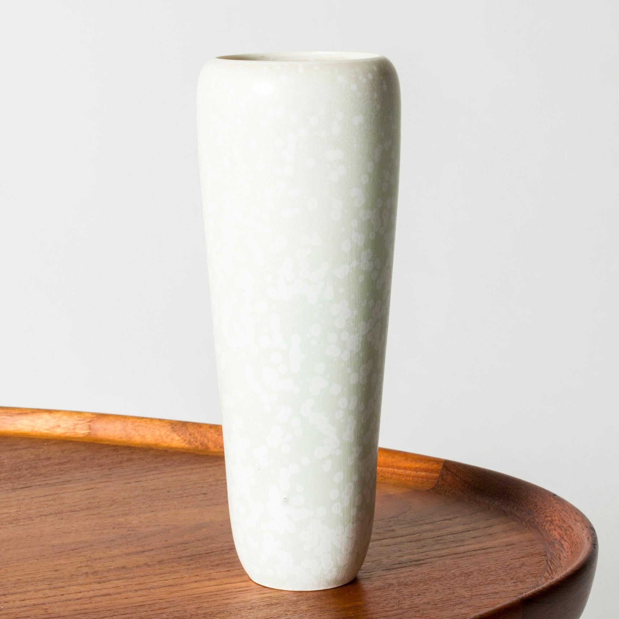 Eleganza e unicità del vaso in gres di Carl-Harry Stålhane, con una forma liscia e affusolata e un'ampia tesa. Smalto bianco guscio d'uovo con motivo 