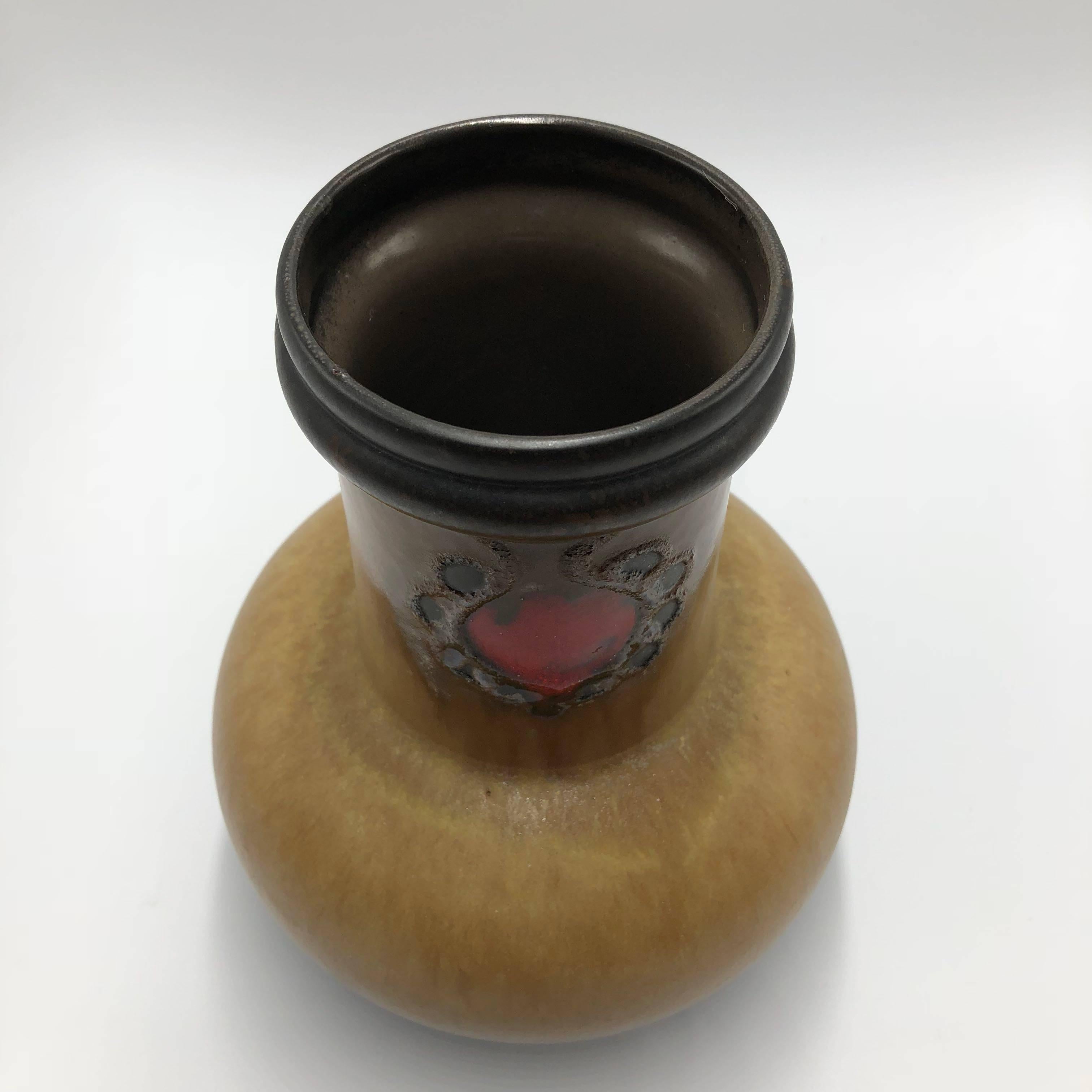 Ceramic vase in excellent condition manufactured by Strehla (GDR former East Germany) Identification. Dark brown edges and inside, the centre of the vase is beige with a beautiful red floral image.

The great majority of Strehla items are marked