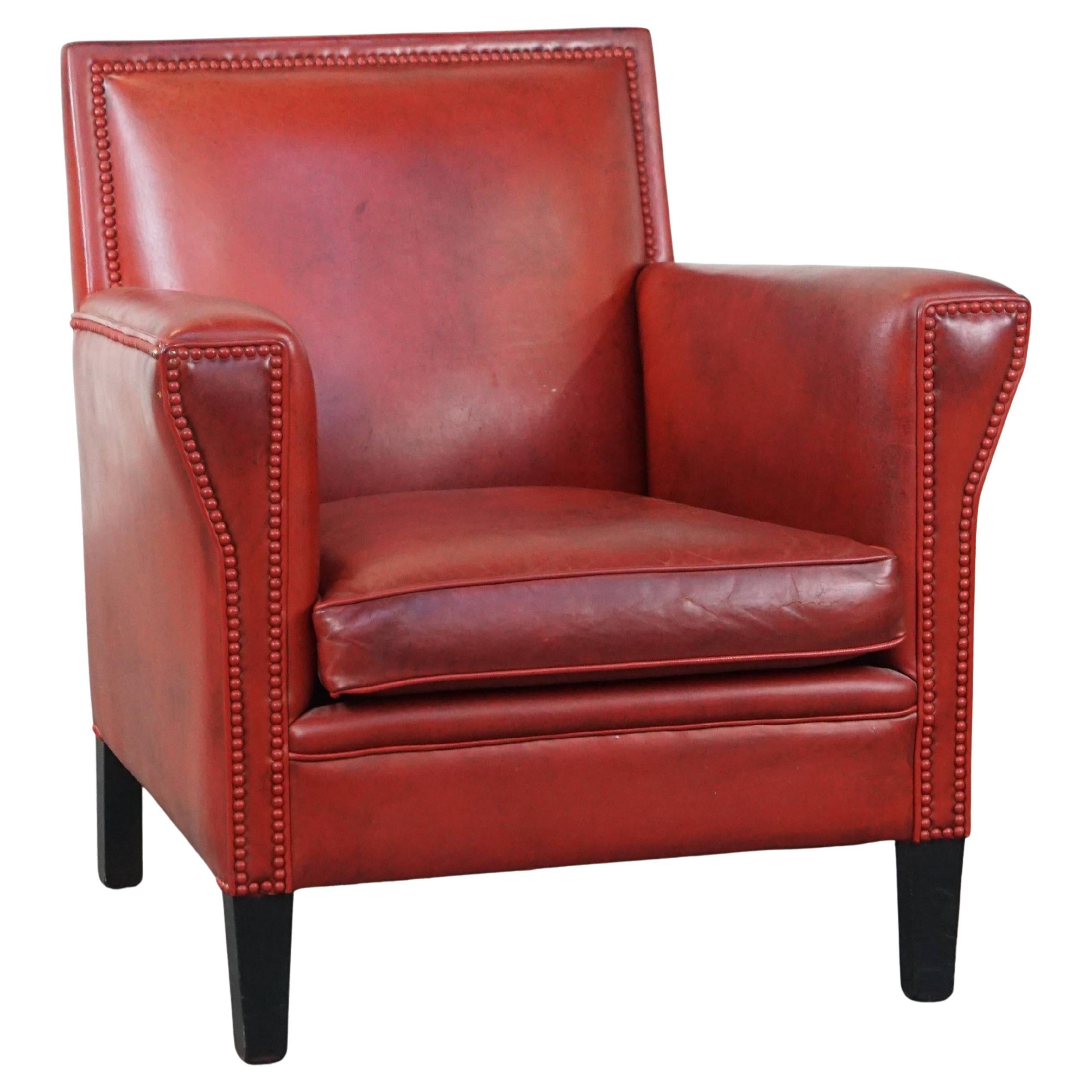 Unique, stylish red-painted armchair made of sheepskin