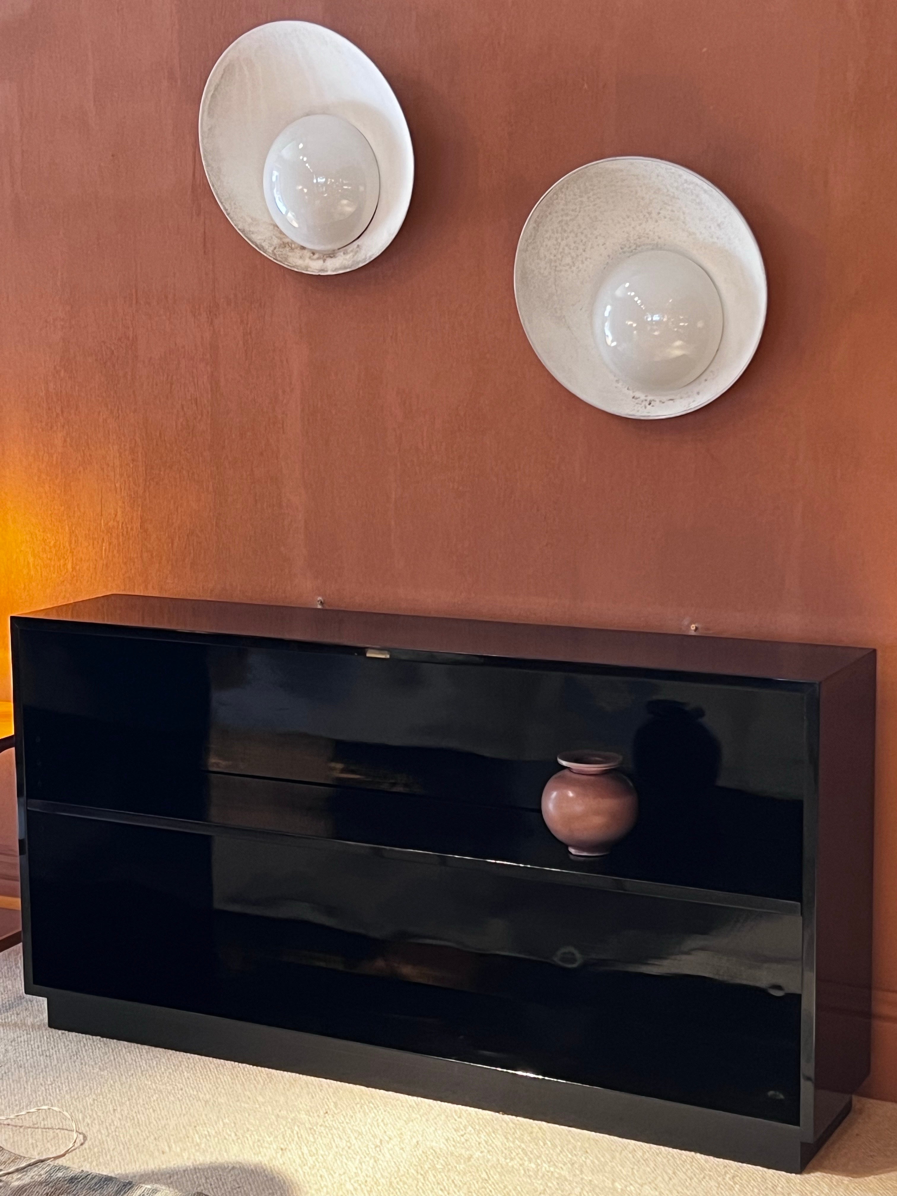 Única, minimalista y elegante estantería lacada de los años 30. Un estante regulable en altura en 7 posiciones diferentes. Lo tenemos completamente restaurado, pero aún presenta algunas huellas, ya que se trata de un trabajo manual. Tenemos un par