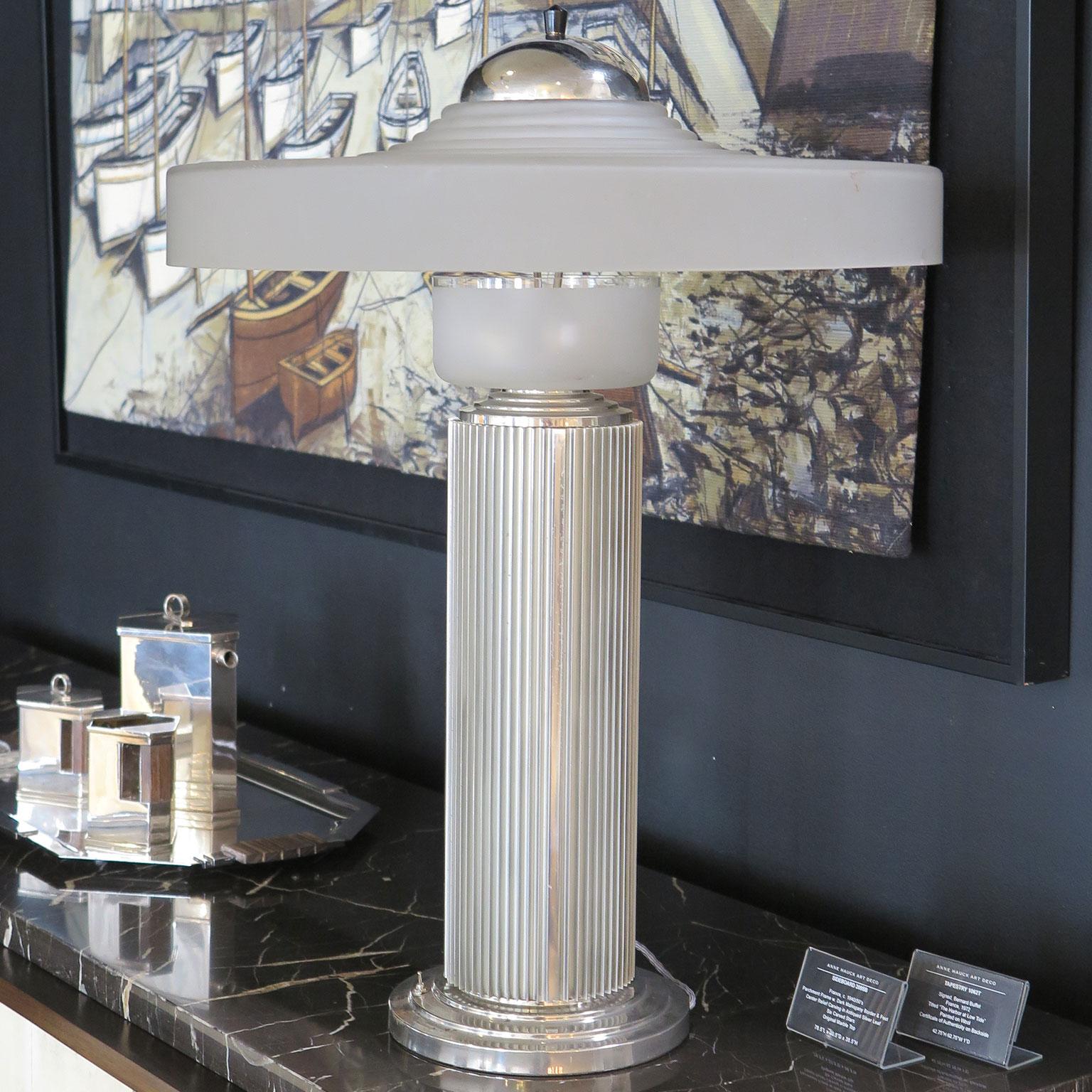 Unique tall table lamp attributed to Georges Leleu in nickel with linear ribbed detailing along the stem. The stepped, frosted glass shade with a nickel hat and finial, sits on top of a frosted glass cup housing the lightbulbs.