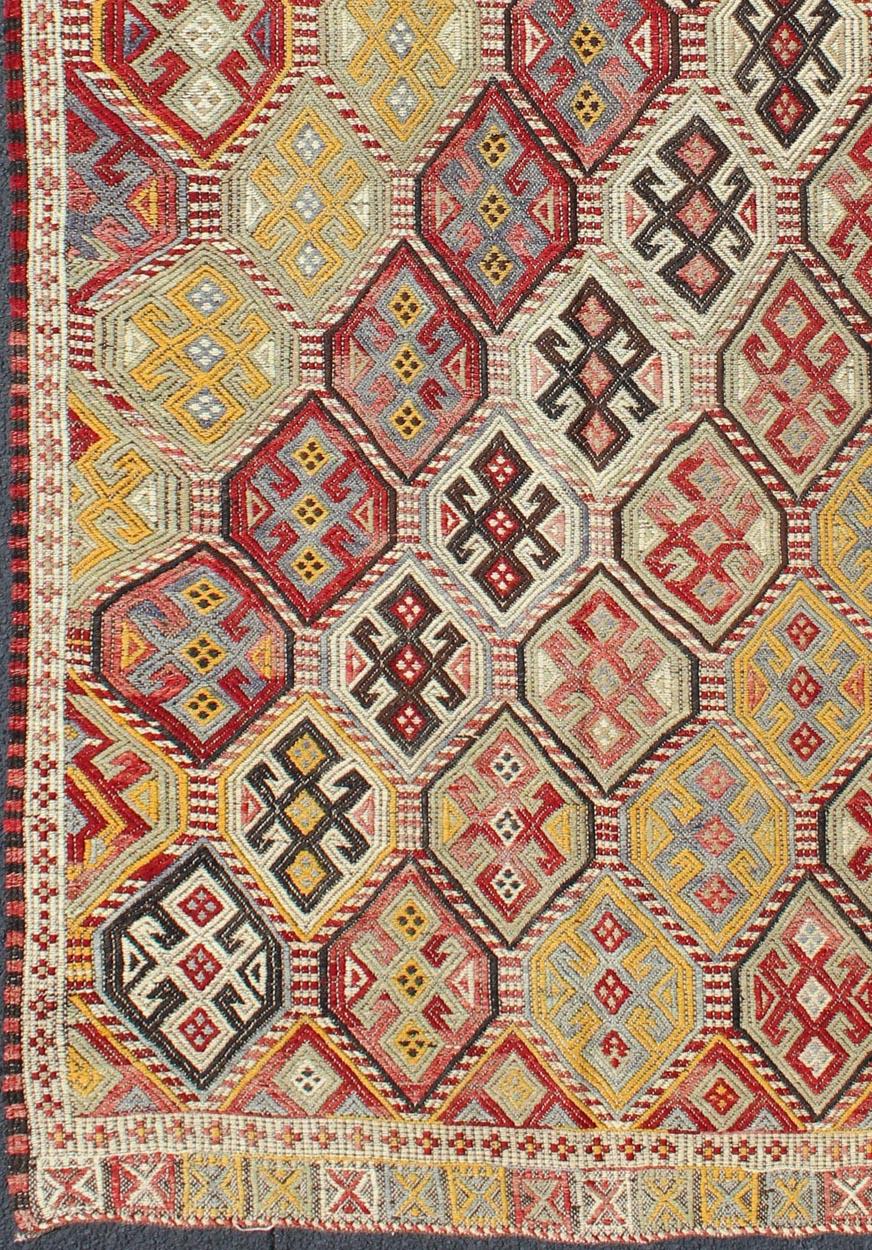 Featuring tribal diamond shapes with a spotted and speckled assortment of geometric elements, this finely woven embroidered Kilim showcases an array of rich colorful tones. Colors include red, white, yellow, grey, and brown.
Measures: 4'3 x 8'10.