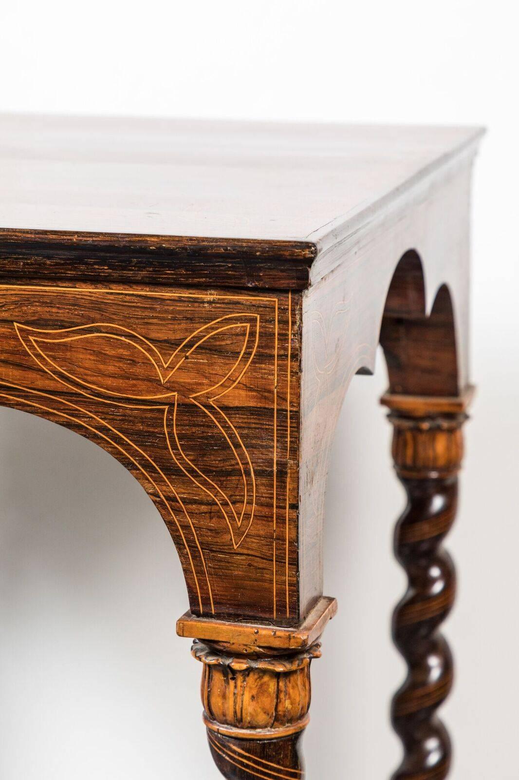 Unusual, beautifully carved, partially ebonized, spiral leg occasional table with a tri-part arched apron, and both foliate style and stringing inlay details throughout.