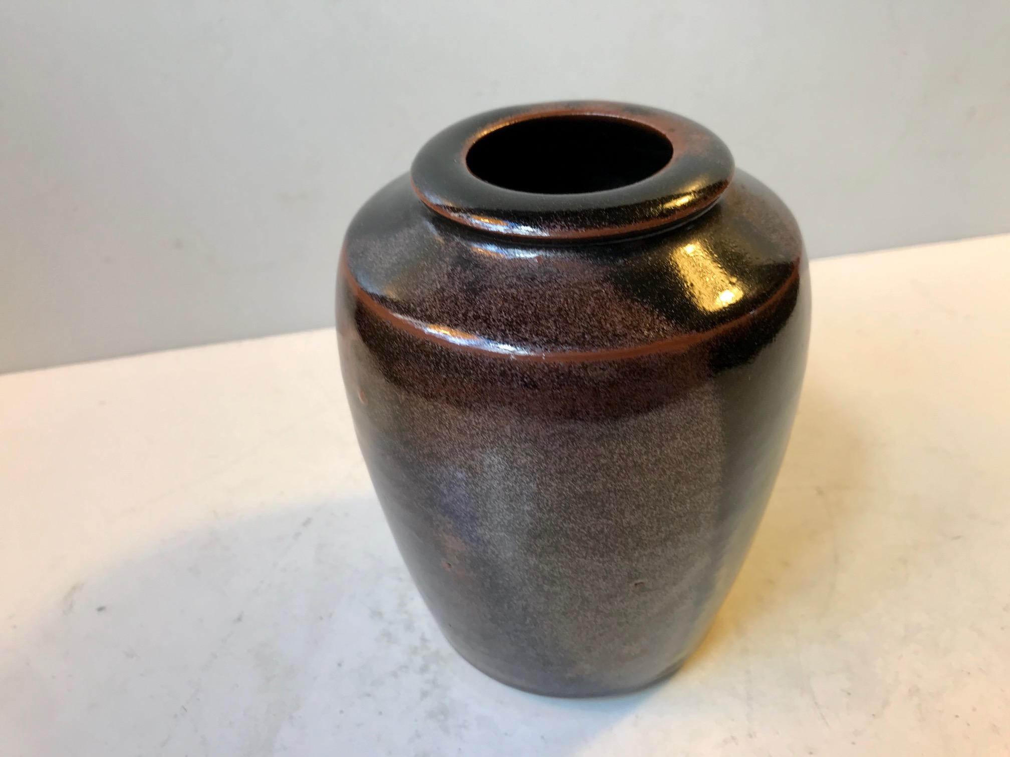 Unique Studio vase from the hands of Danish ceramist Merethe Bloch. It dates from the latter part of the 1970s and is executed in stoneware and decorated in earthy/metallic tenmoku glazes. It is signed by hand to its base: MB.