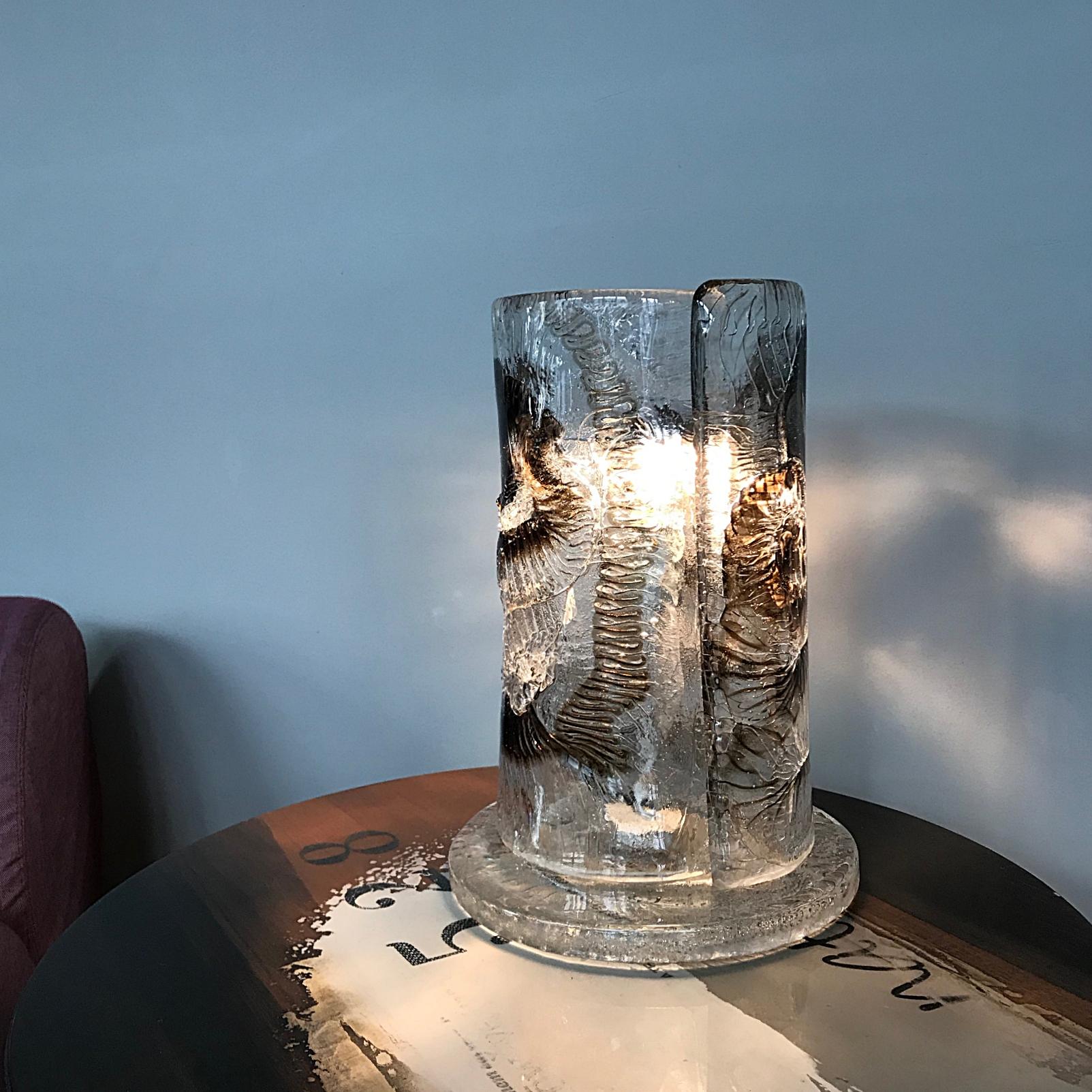 Très rare lampe de table de l'ère spatiale conçue et fabriquée par Venini, Venezia. La lampe est faite de verre d'art Murano très lourd qui contient des bulles d'air et des poissons fossiles stylisés, la lampe fournit une lumière douce et
