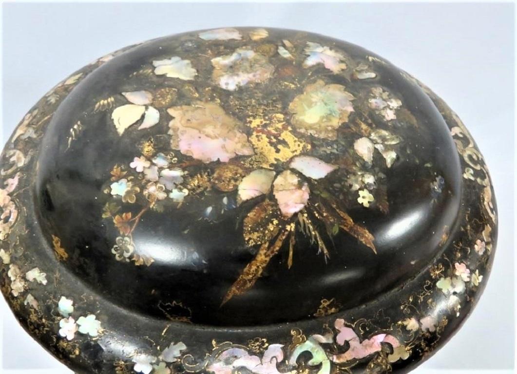 Rare Victorian (c. 1850) lacquered papier-mâché jewelry box with inlaid mother of pearl and gilding depicting a floral motif. The mother of pearl looks of high quality and shimmers with shades of blue and rose. Gilded leaves are interspersed with