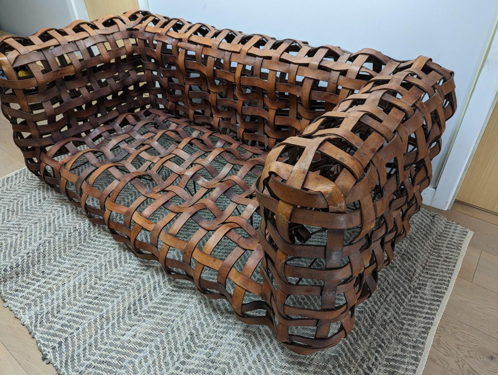 A unique vintage 2 person brown leather strap sofa.

The leather straps are connected to a metal welded frame which produces this highly unusual sofa.

The sofa has recently been rewelded and more support added underneath

The sofa would need