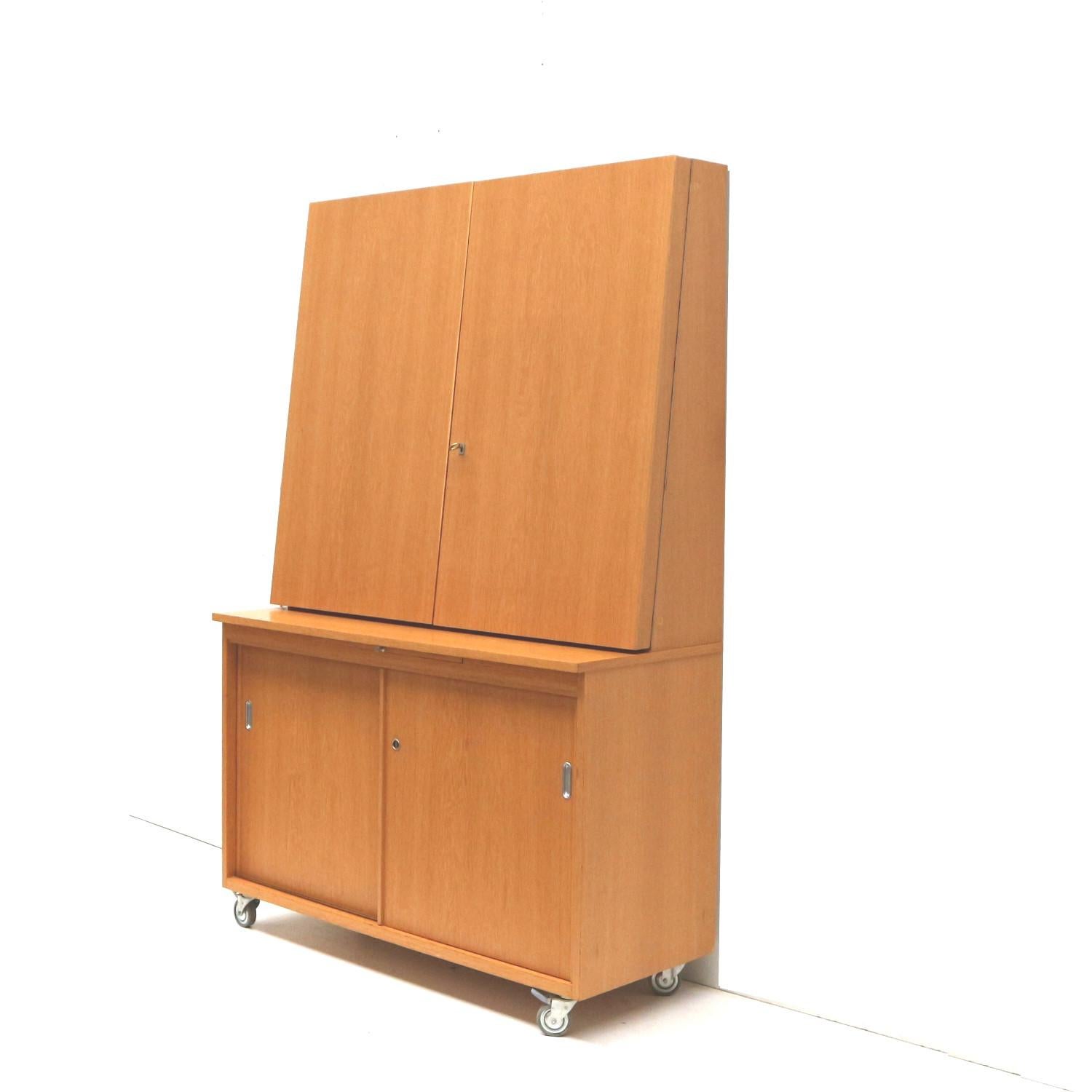 Unique vintage cupboard / sideboard / bookcase made in the 1970s.

Dimensions:
Width (folded): 119 cm
Width (unfolded): 236.5 cm
Height: 185 cm
Depth: 50 cm

The cabinet hassigns of use consistent with its age.