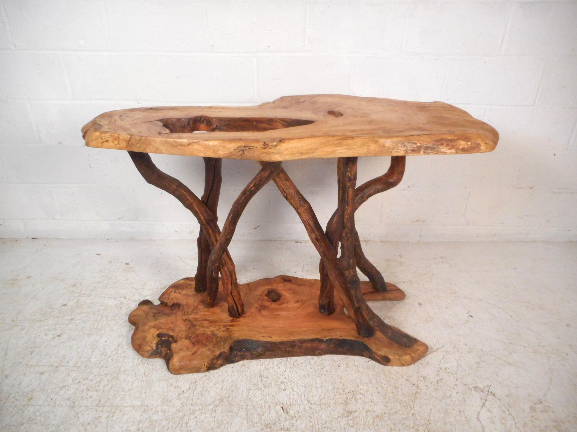 Very unusual vintage live-edge console table. Stunning wood texture and wild yet sturdy supports connecting the base and tabletop. An interesting piece sure to add a lively dimension to any decor. Please confirm item location with dealer (NJ or NY).