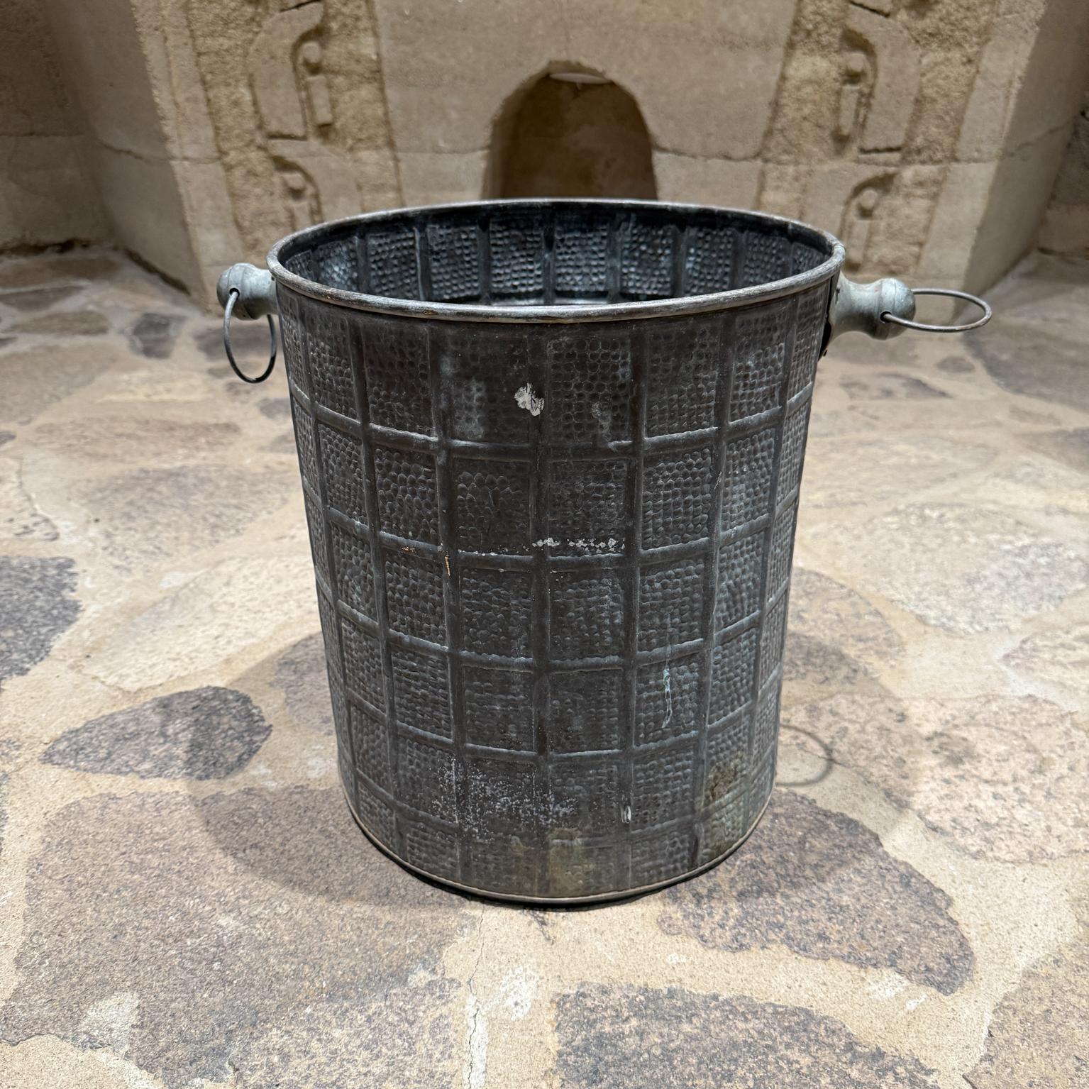 For your consideration, a unique vintage planter or bucket, hand hammered. Handles  on either side. 

Unmarked. No label present. 
It appears to be brass with original unrestored verdigris patina.
It seems the basket was used as a planter. The