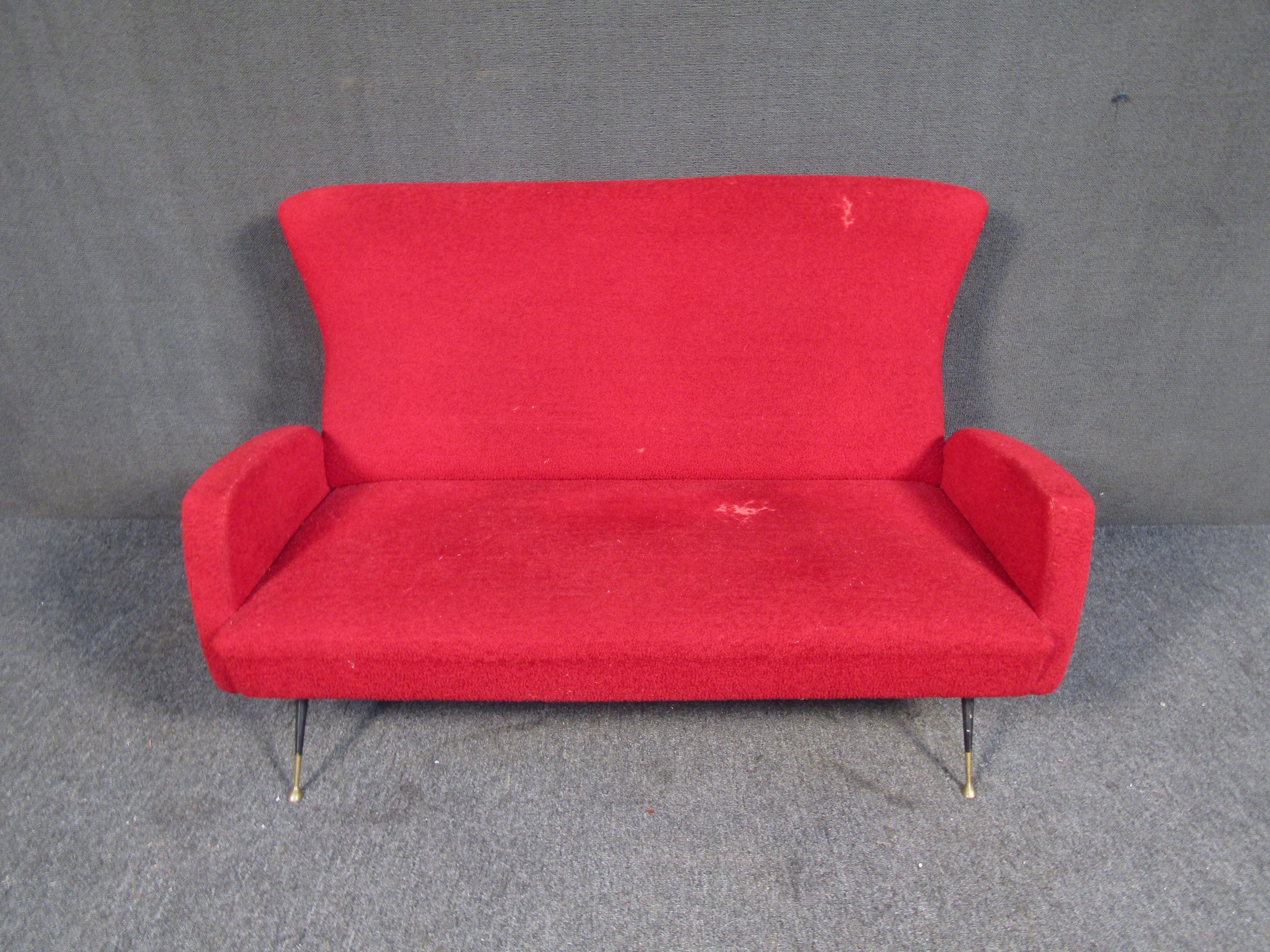 This Wingbacked loveseat is covered in red fluffy fabric and features, tapered metal legs with brass feet. A very unique eye catching piece that would add pop and a bit of flare to any room. 

Please confirm item location with dealer (NJ or
