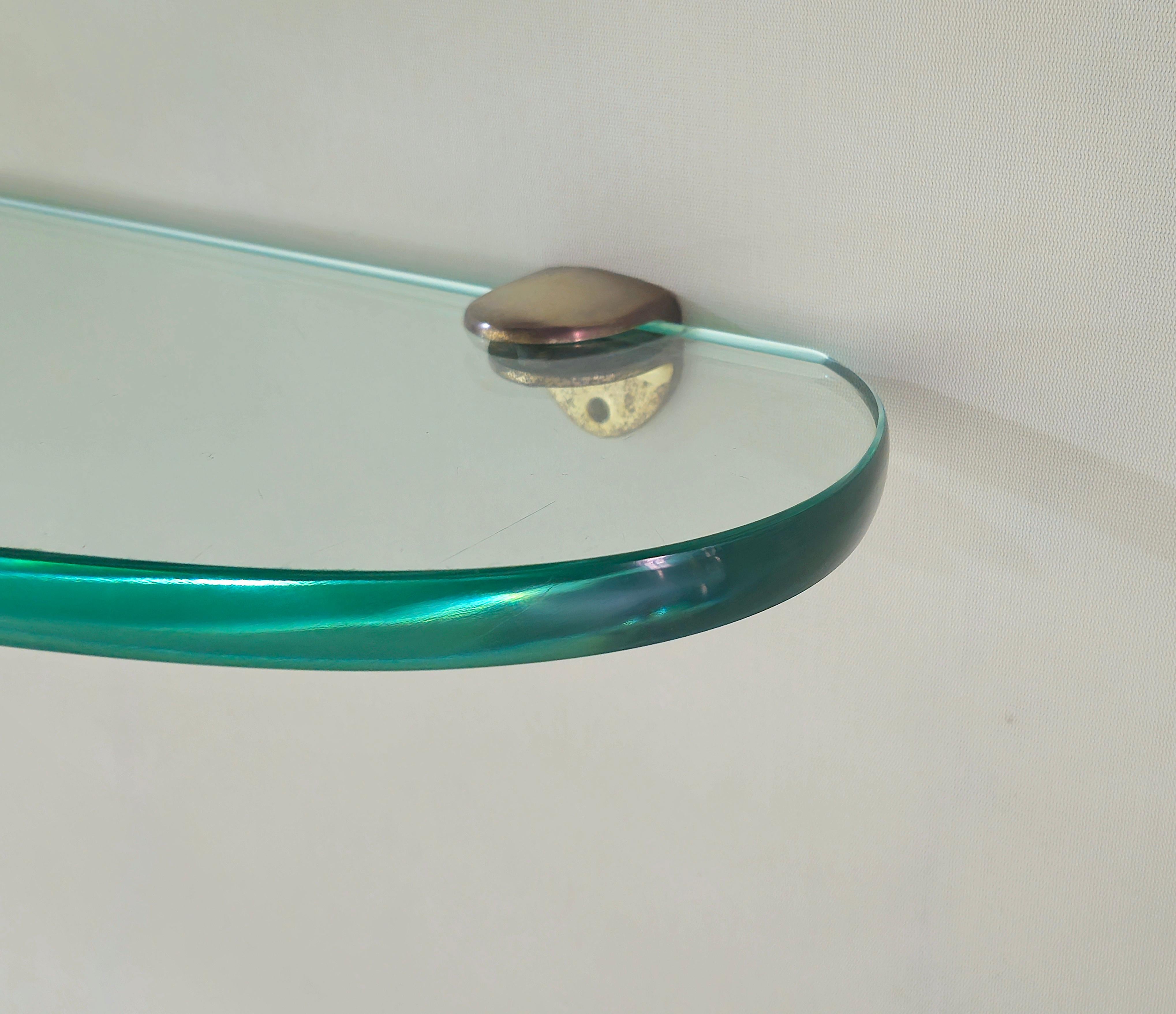 Fontana Arte , rare and elegant wall shelf, Nile green glass of great thickness, shaped and ground transparent. Sturdy brass supports of excellent workmanship. All you need are two elements, glass and brass and here is a beautiful piece of furniture