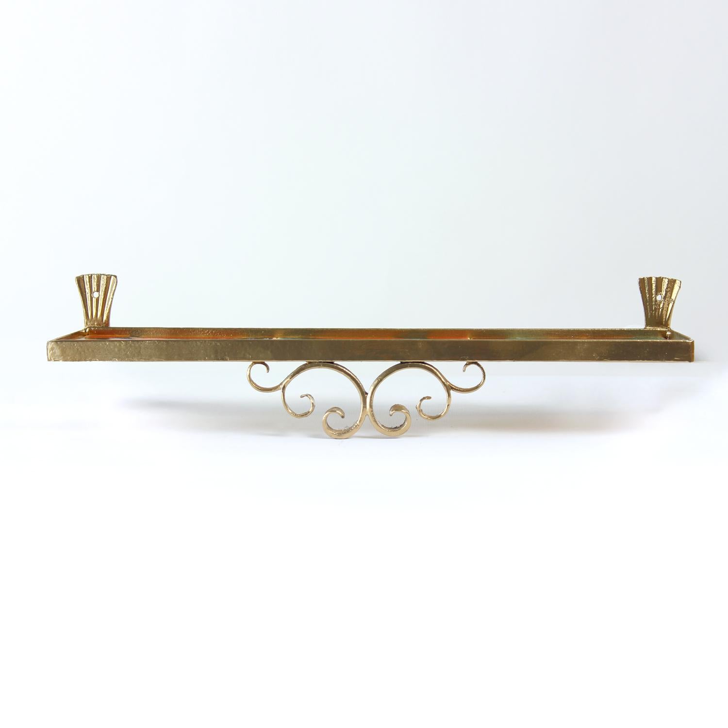 Un pezzo bellissimo e unico. Si tratta di una mensola da parete con struttura in metallo e ornamenti nella parte anteriore. La struttura in metallo e acciaio è rifinita in colore oro. Il ripiano stesso è composto da tre piastrelle di ceramica. Le