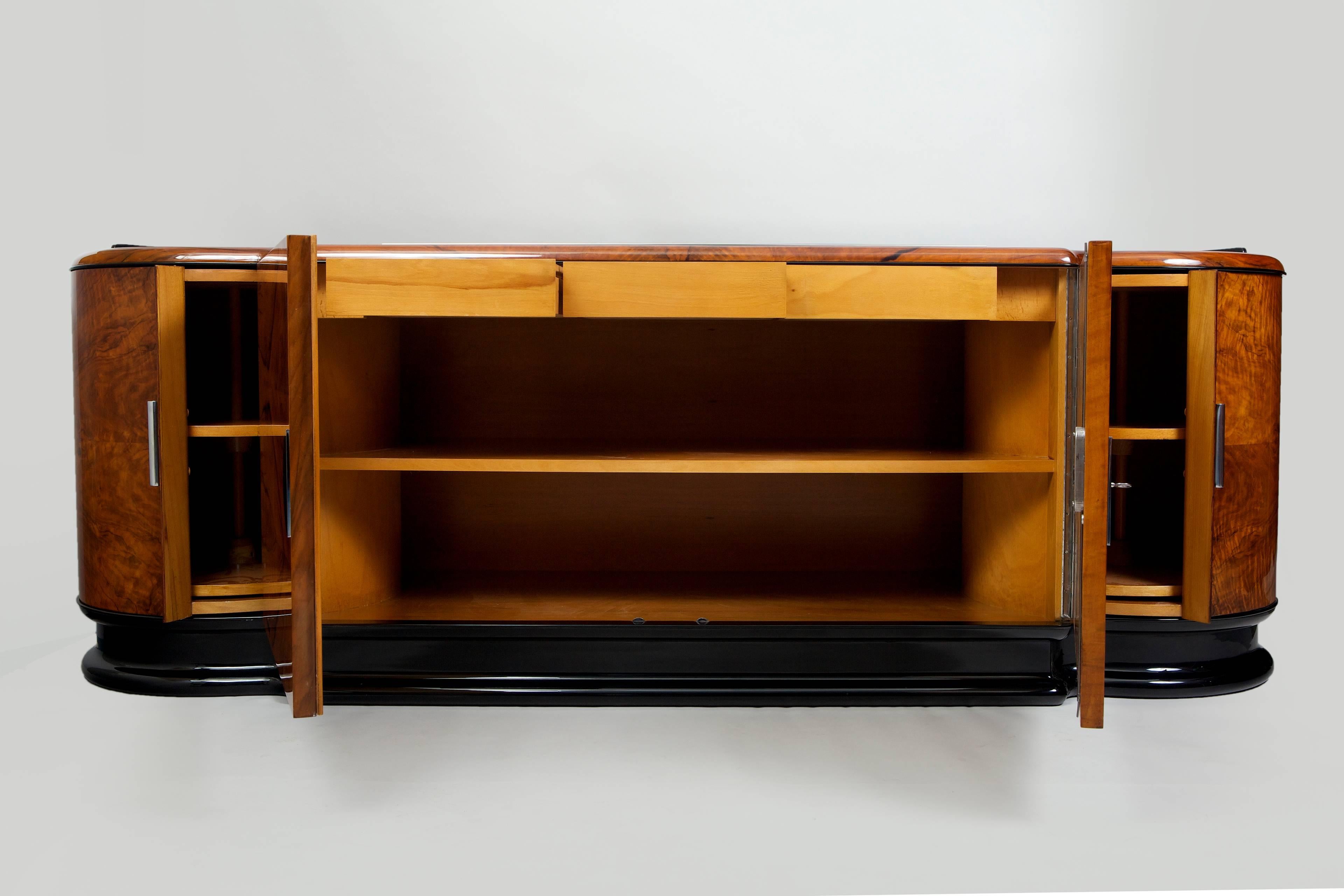 Art Deco sideboard.
Czechoslovakia
Walnut veneer. 
Surface was made by piano lacquers to the high gloss. 
Completely restored.

We guarantee safe a the cheapest air transport from Europe to the whole world within 7 days.
The price is the same as for