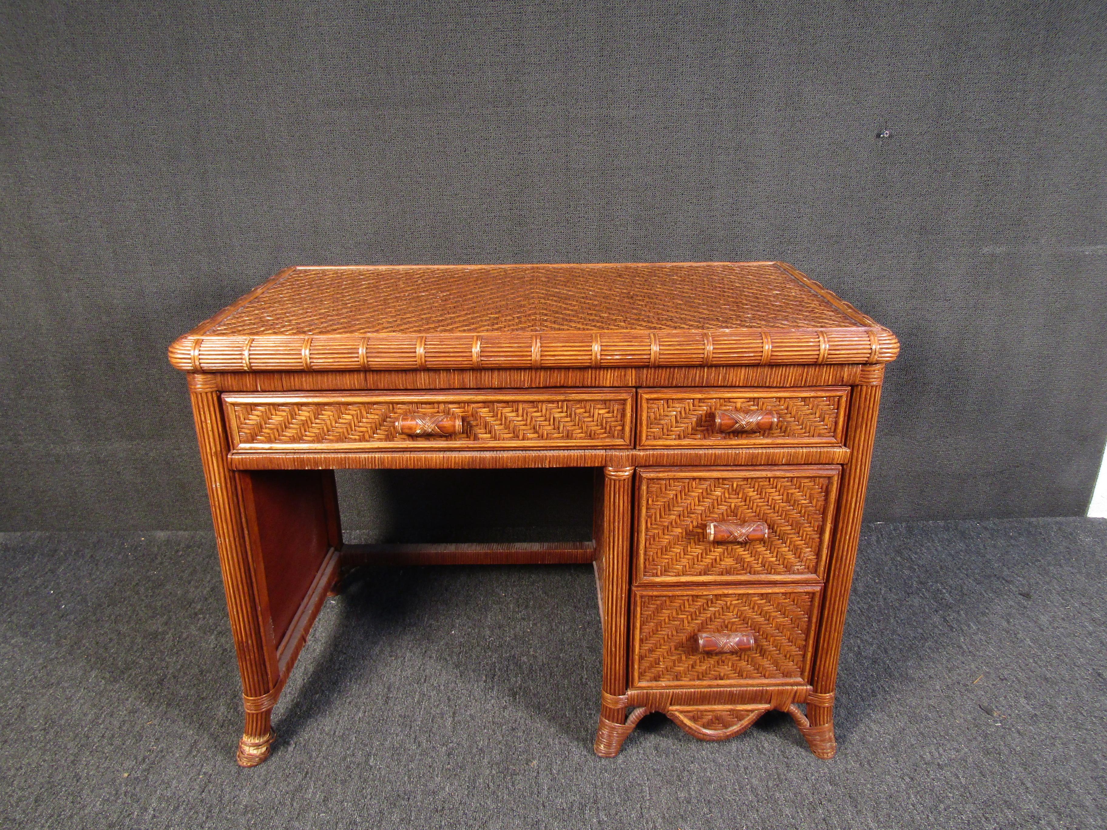 An unusual Mid-Century Modern desk made of bamboo and wicker, this small desk is sure to be a conversation-starter anywhere it's placed. Four drawers with beautiful woven fronts allow for storage and organization. Please confirm item location with