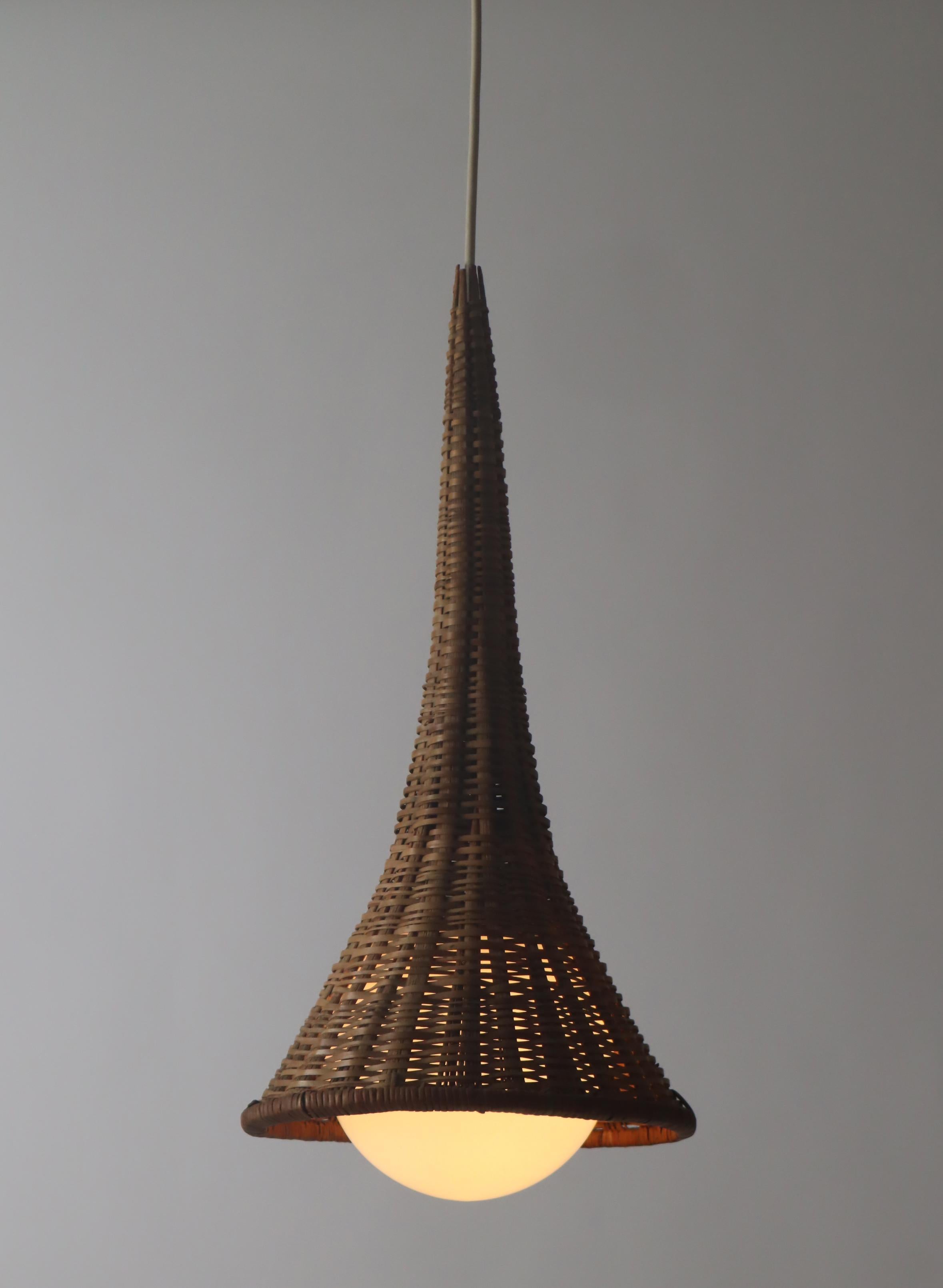 You will be amazed by the extraordinary lamp made by an artist in the shape of a witch's hat, combined with a spherical glass that is powered by an E14 bulb. The combination of the hand-woven rattan and the white glass is unique and will delight