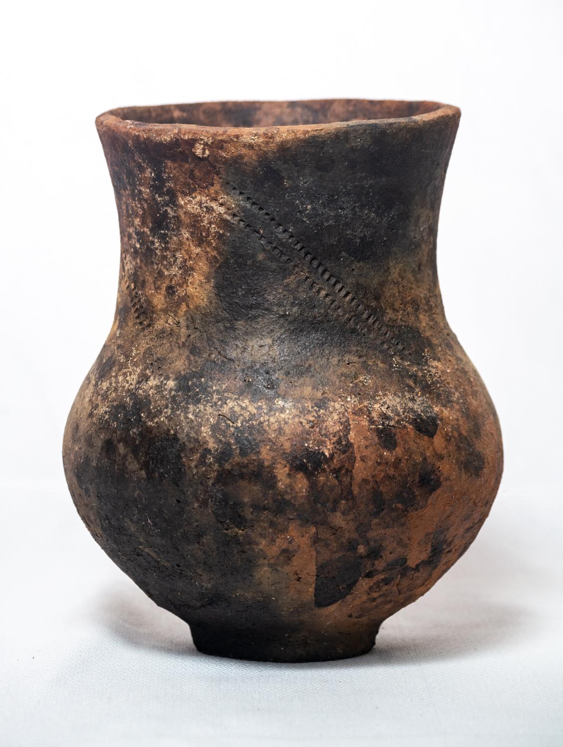 Prova il fascino dell'artigianato con il nostro vaso unico in Wood and Wood. Questo splendido pezzo è realizzato con argilla di provenienza locale e cotto con una tecnica tradizionale a base di cenere di legno che permette di ottenere texture e