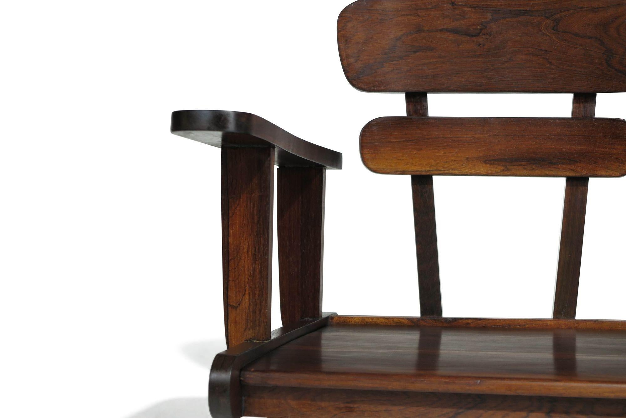 Questa eccezionale coppia di poltrone scultoree è realizzata a mano in Brasile con legno massello di palissandro di alta qualità, che presenta venature scure e venature scure evidenti. La meticolosa selezione del legno da parte dell'artigiano mette