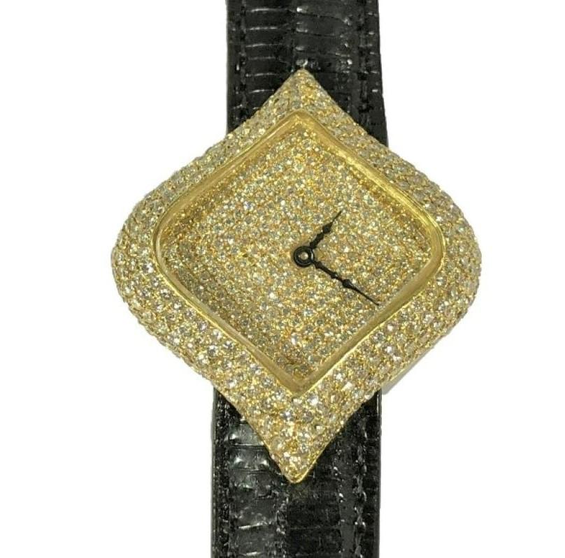 This uniquely shaped, diamond encrusted, large, 18k yellow ladies watch, is made with extreme attention to every detail, including the crown, which is artfully covered. The high quality of all materials used is clearly the signature of an item that