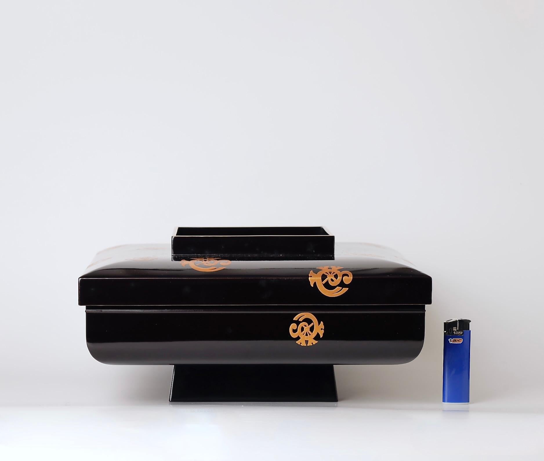 An impressive and unusually shaped Japanese lacquered box, bearing the gold crests of the prestigious Tachibana samurai clan. This elegant piece dates to the late Edo to early Meiji period and was part of a rare and extensive dining set associated