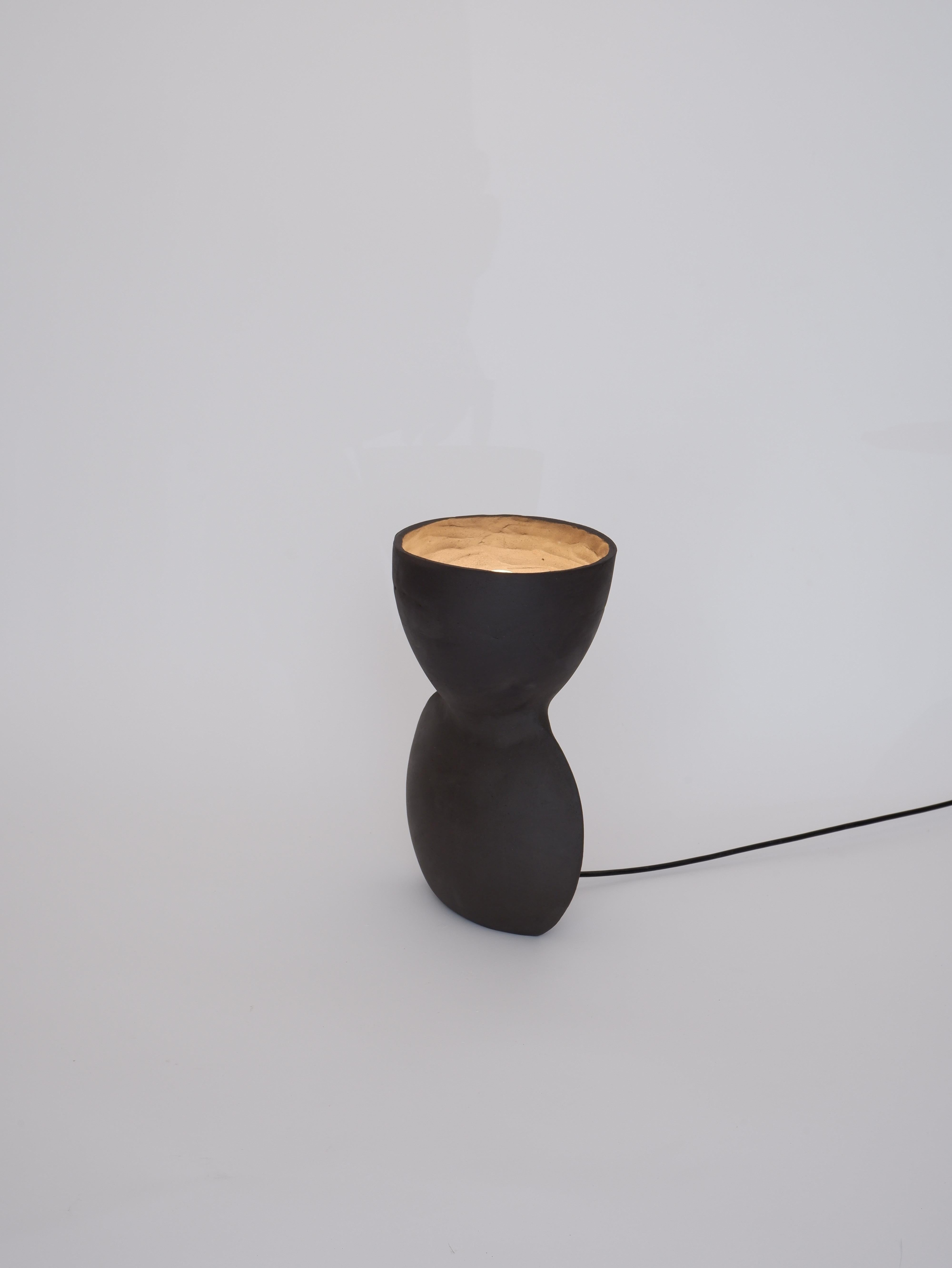 Unira Big Black Lamp by Ia Kutateladze
One Of A Kind.
Dimensions: D 17 x W 23 x H 32 cm.
Materials: Clay.

Each piece is one of a kind, due to its free hand-building process. Different color variations available: raw black clay, raw white clay and