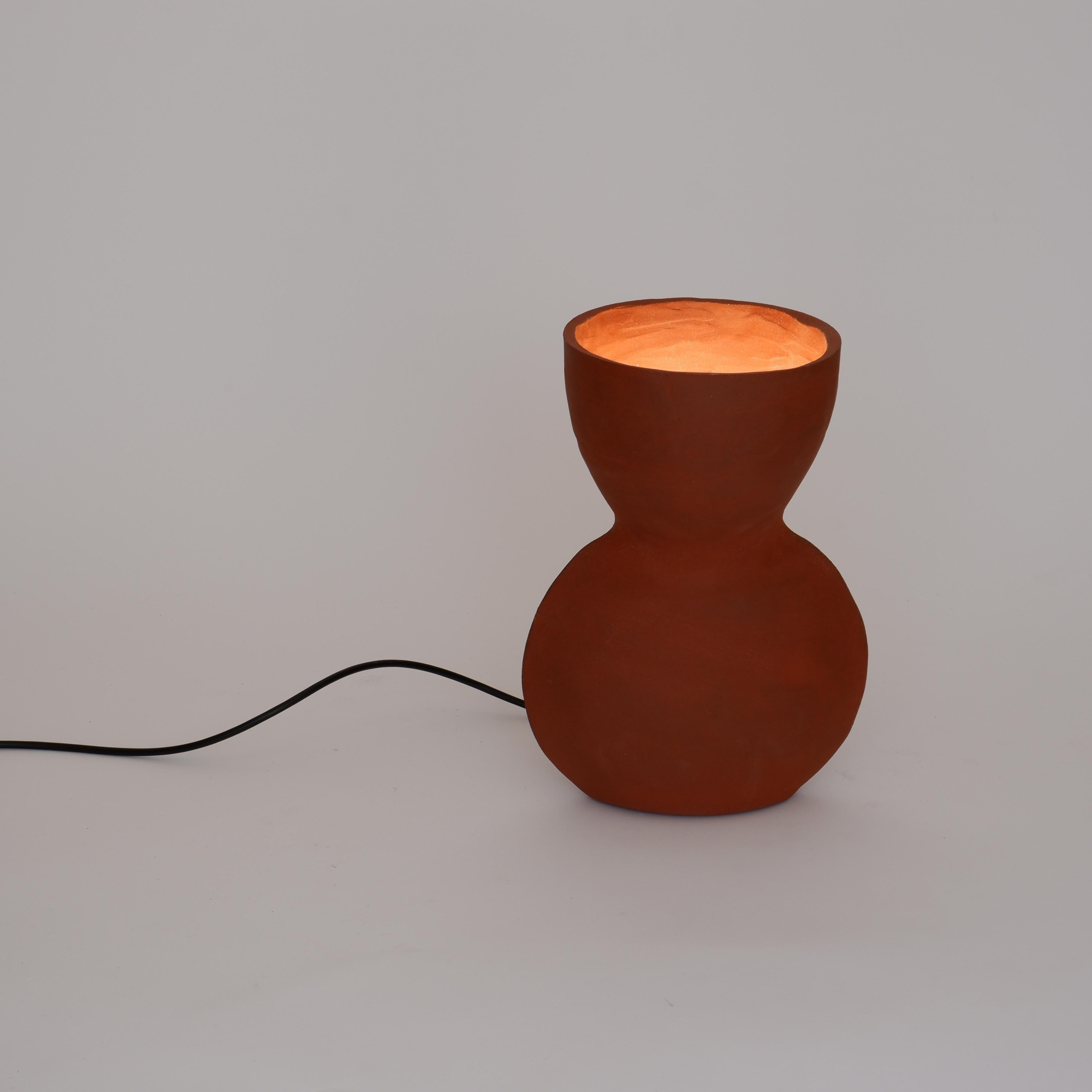Unira Big Red Lamp by Ia Kutateladze
One Of A Kind.
Dimensions: D 17 x W 23 x H 32 cm.
Materials: Clay.

Each piece is one of a kind, due to its free hand-building process. Different color variations available: raw black clay, raw white clay and raw