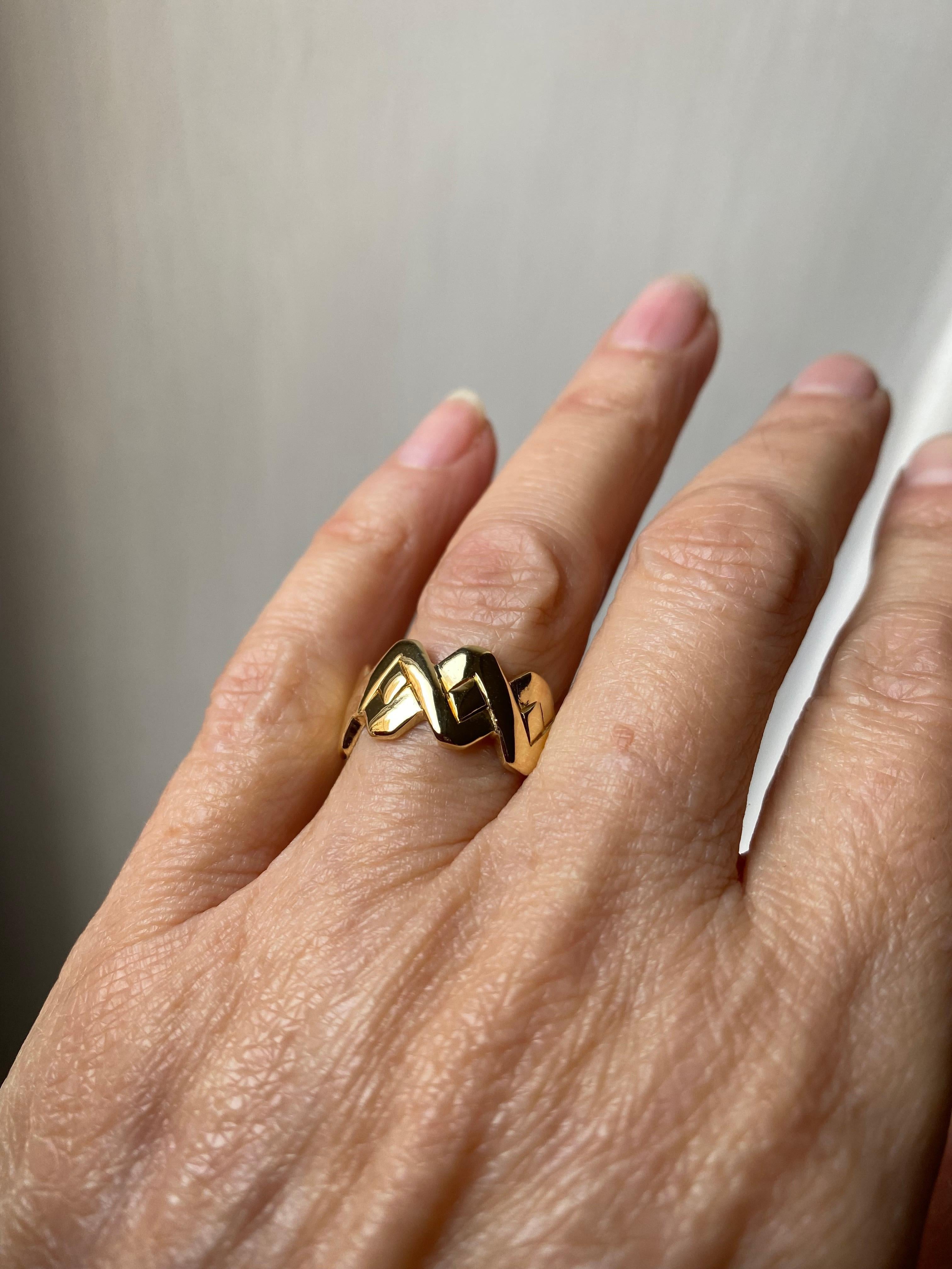 Rossella Ugolini Design Collection, Handgefertigter Unisex-Ring in gedrehter Form. Die handgeschnitzte Oberfläche ist mit zwei gewundenen Streifen versehen, die in der Mitte einen quadratischen Raum bilden. Ein Schmuckstück für jeden Tag, ein