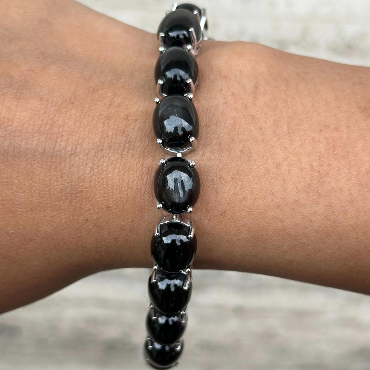 Das Unisex 63,1 Carat Black Star Tennis Armband aus Sterlingsilber präsentiert einen unendlich funkelnden, natürlichen blauen Stern mit einem Gewicht von 63,1 Karat. Es misst 7 Zoll in der Länge. 
Black Star fördert die Konzentration und baut Stress