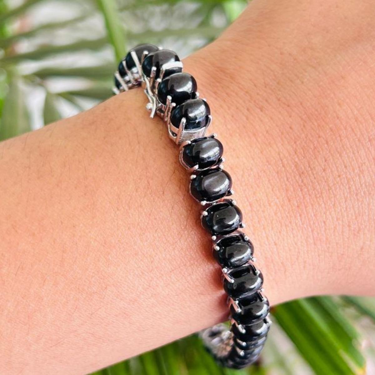 La pulsera de tenis unisex Estrella negra de 63,1 quilates, de plata de ley, luce una estrella negra natural de 63,1 quilates que brilla sin cesar. Mide 7 pulgadas de largo. 
La Estrella Negra estimula la concentración y reduce el estrés. 
Diseñada