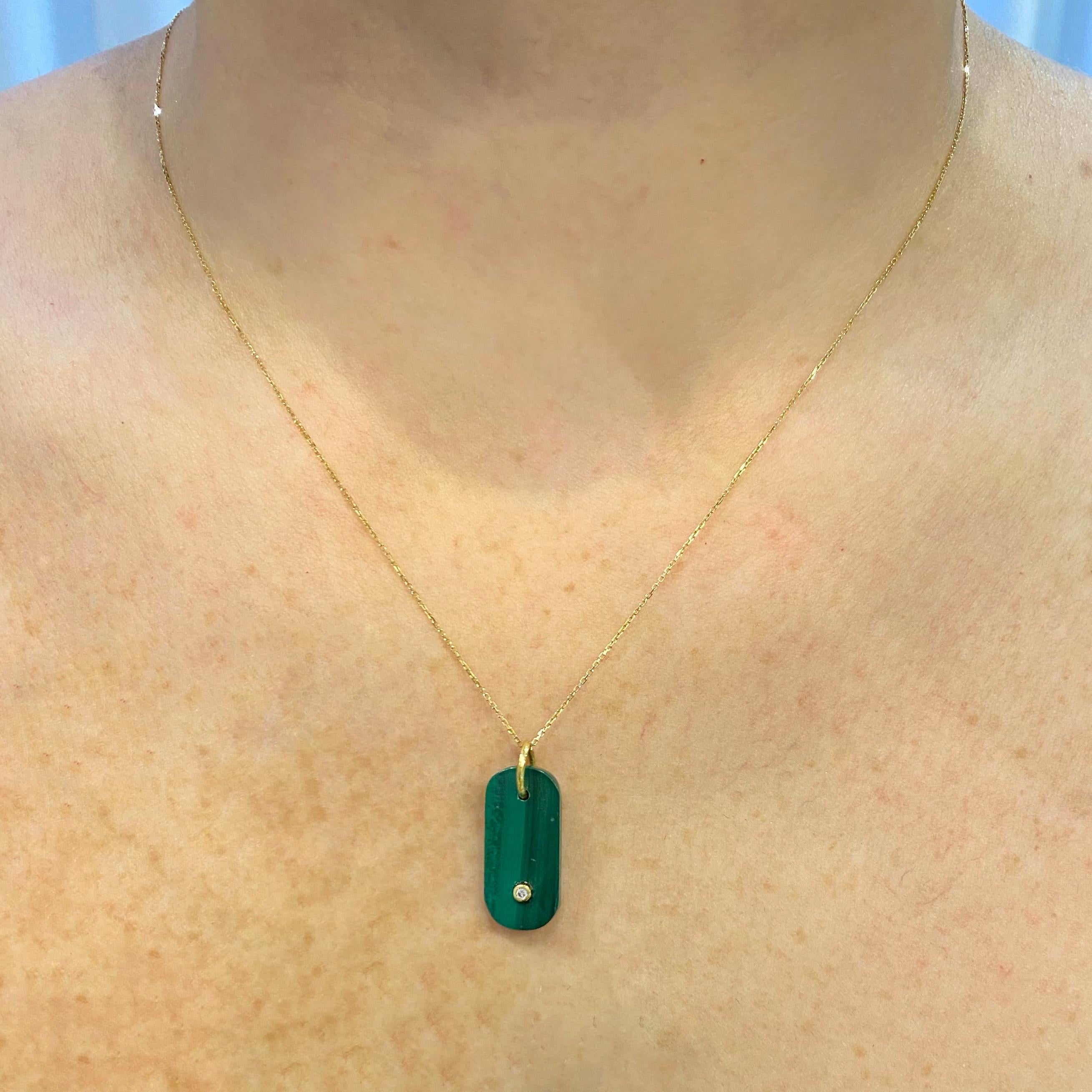 Add a touch to your look with this gender neutral malachite pendant adorned with a GVSI diamond in 18K yellow gold and chain. The quality of the diamond makes it spark over the intense natural malachite green color. This pendant is part of our