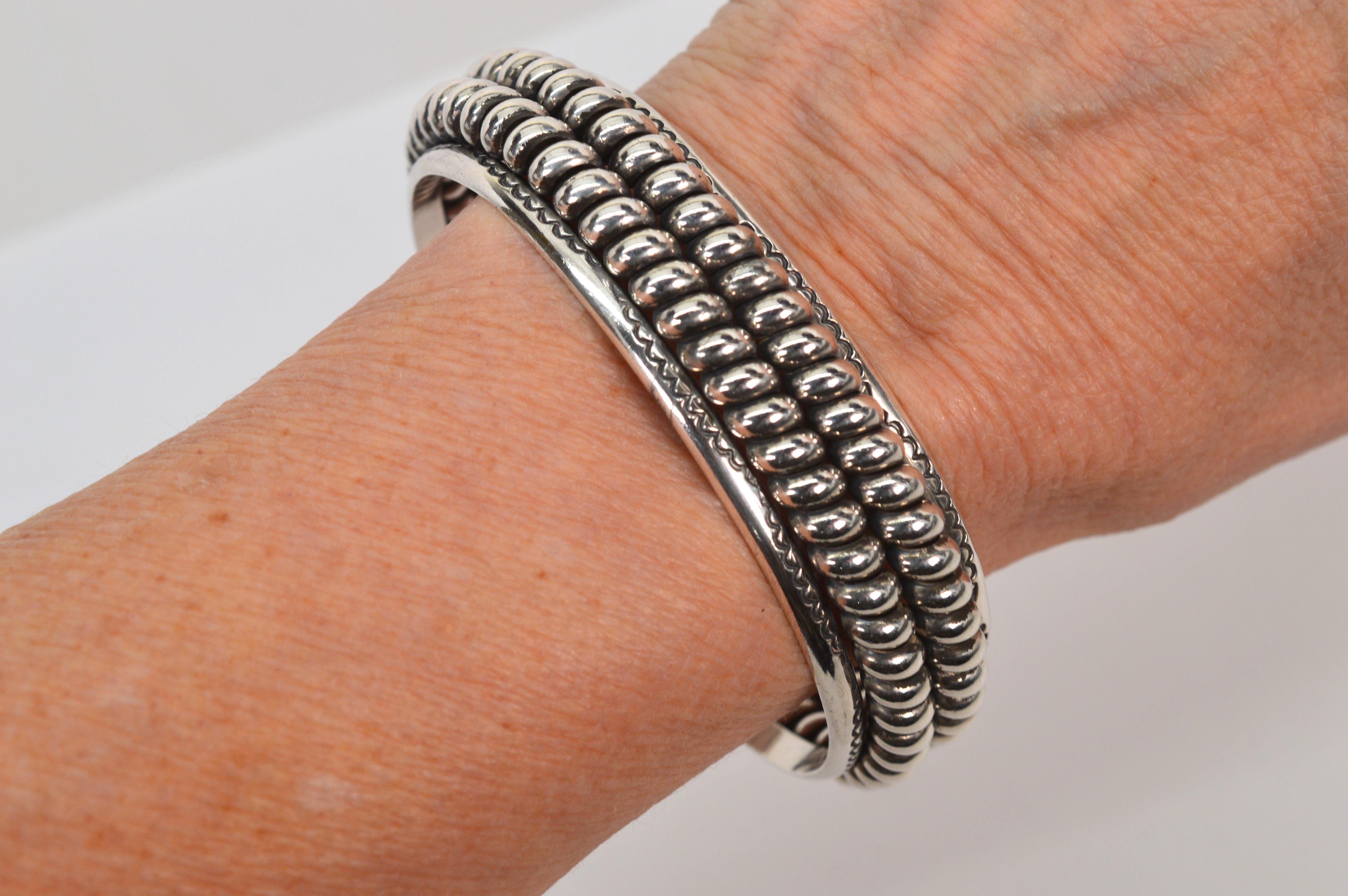 Twists of heavy gauge sterling silver create the attractive elevated double row pattern seen from end to end of this substantial 3/4 inch wide Navajo cuff bracelet. Tiny hand engraved details embellish the front placket. Unisex sizing for larger