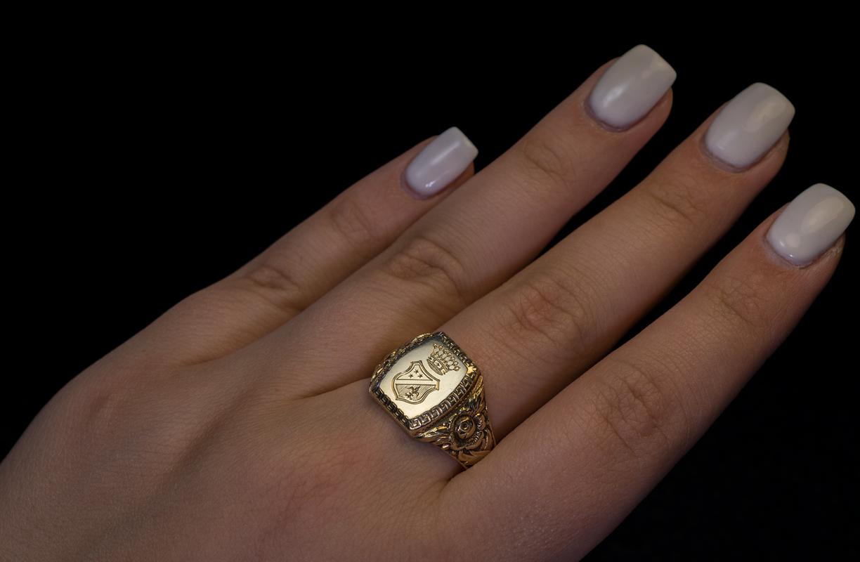 Made in Vienna, Austria in the 1930s.

The shield-shaped matrix of this vintage 14K gold unisex signet ring is engraved with a coat of arms surrounded by a greek key border. The shoulders of the ring are embellished with floral designs.

The