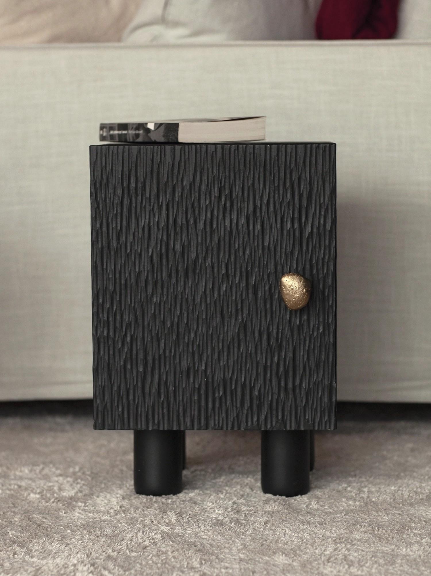 El armario CHISEL está fabricado con madera de fresno maciza, y su superficie está grabada con un intrincado dibujo cincelado. Con una altura de 45 cm, sirve como mueble auxiliar o mesilla de noche perfecta. Con sus líneas limpias y arquitectónicas