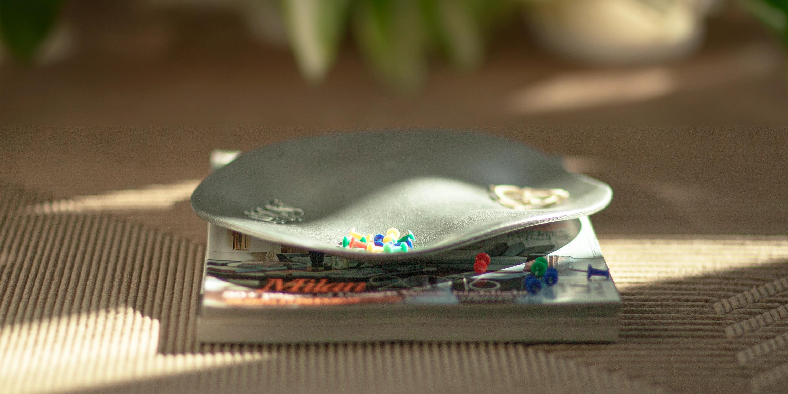 The small Fluid Bowl, with its irregular shape and approximately 23 cm diameter, is crafted using the sand-casting technique. Its organic design, featuring three distinct recesses, makes it perfect for both decorative and practical use, ideal for