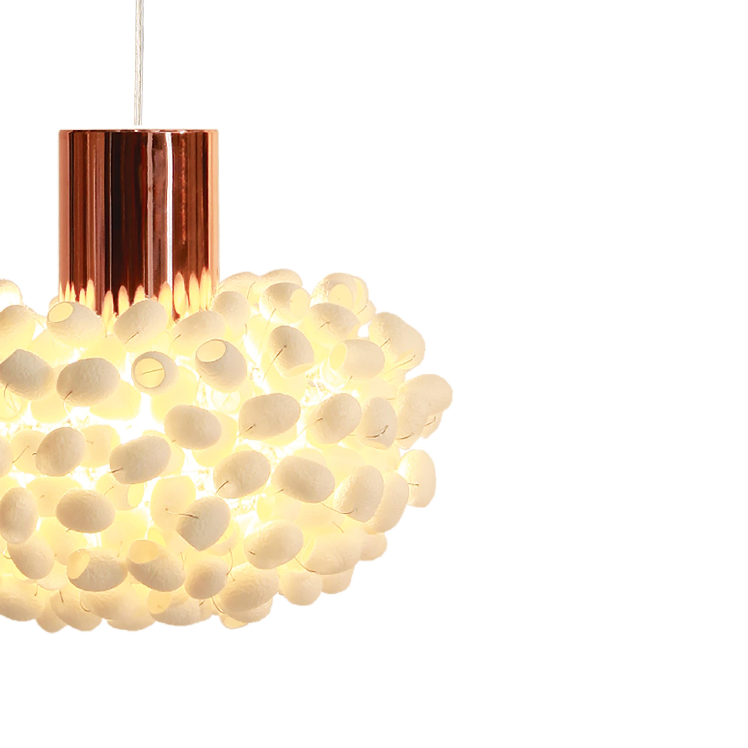 Double pendant light of the Unit Pendant-C by Ango is an exquisite pendant light that captures the magic of light diffused through the natural beauty of silk cocoons. Formed into an elegant ovaloid shape, this light fixture features an atomized