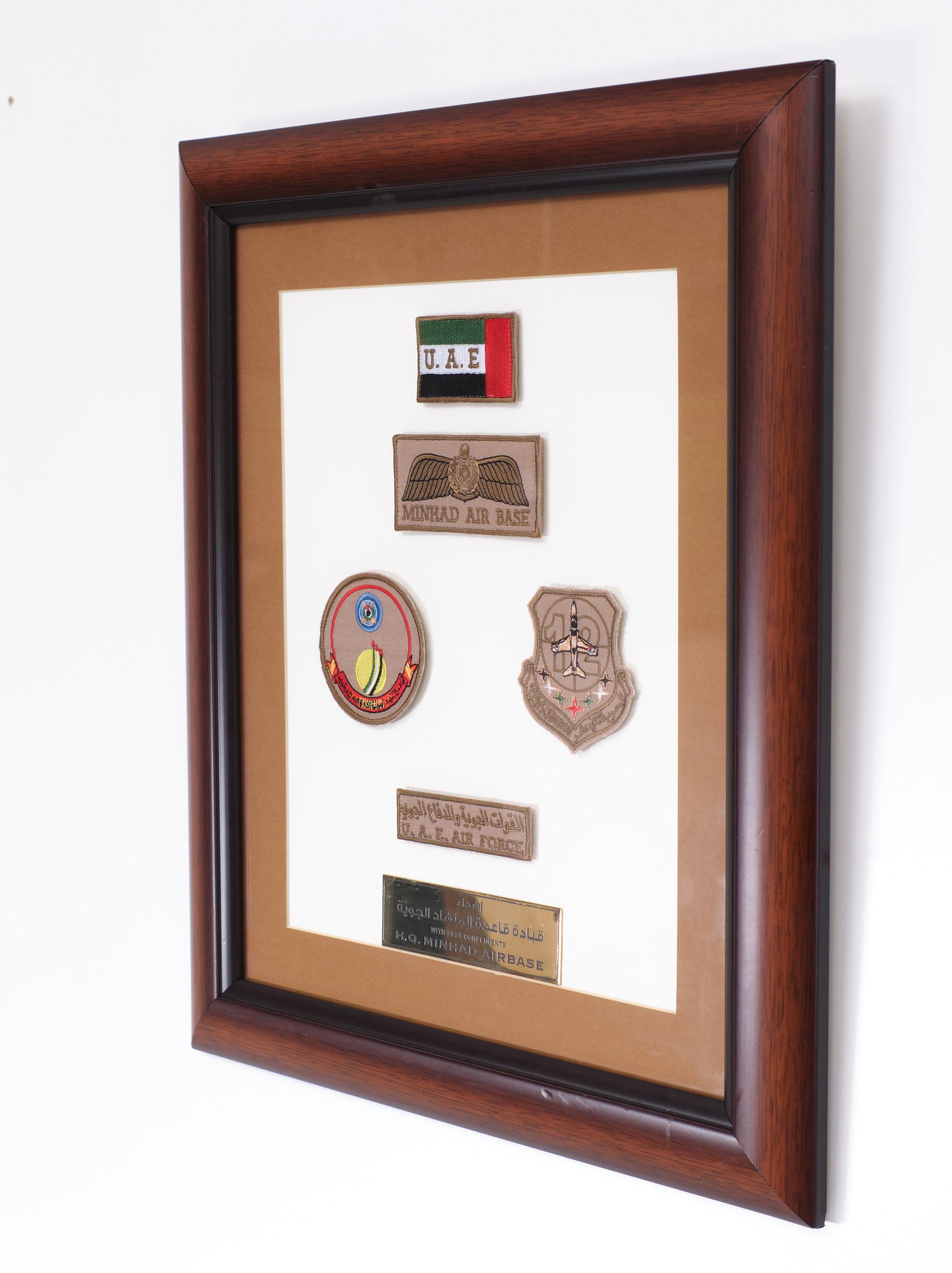 Framed present from United Arab Emirates Minhad Airbase for a fighter plain pilot. 5 Pats and a brass plate.