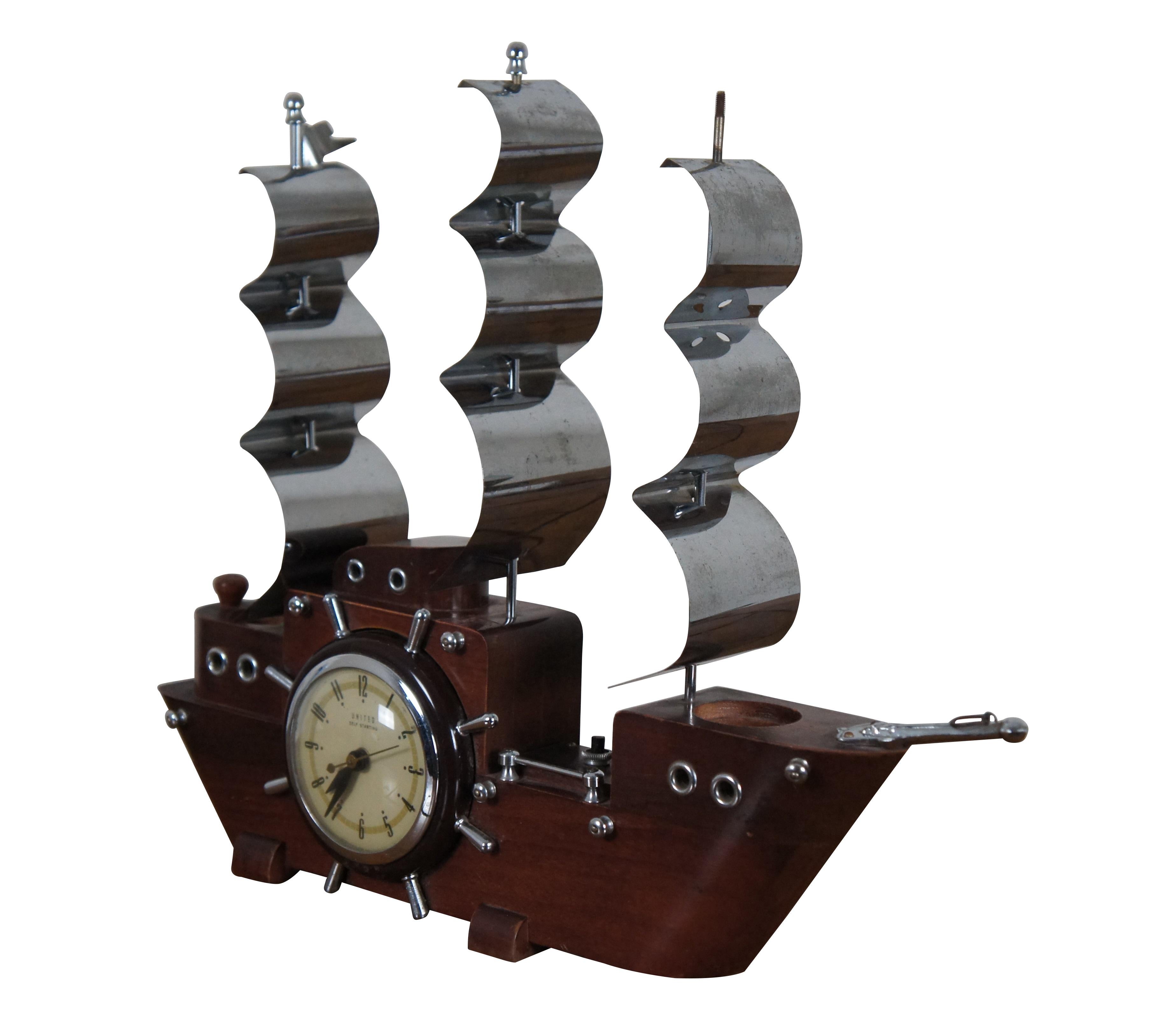 Mid century United Clock Corp. model 811 maritime / nautical theme sailing ship / clipper / boat mantel clock featuring a wood body with ship wheel clock, three metal masts, and up light nightlights.

Dimensions:
19.5