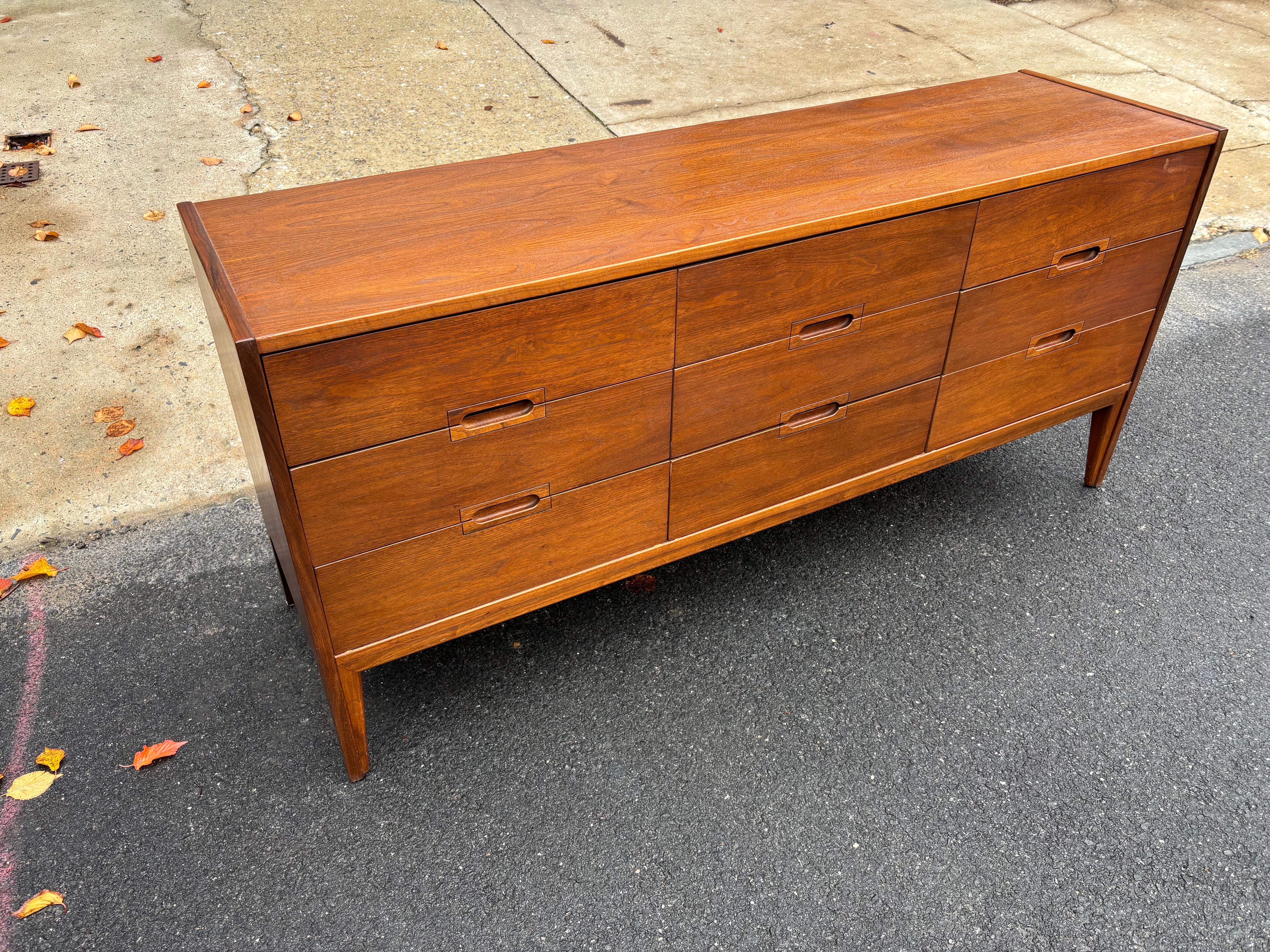 Comò in noce a nove cassetti di United furniture company. Dimensioni e dimensioni molto buone 9 cassetti abbastanza profondi, maniglia incorporata. Il design è molto bello e tutti i cassetti funzionano perfettamente! Il top è stato rifinito.