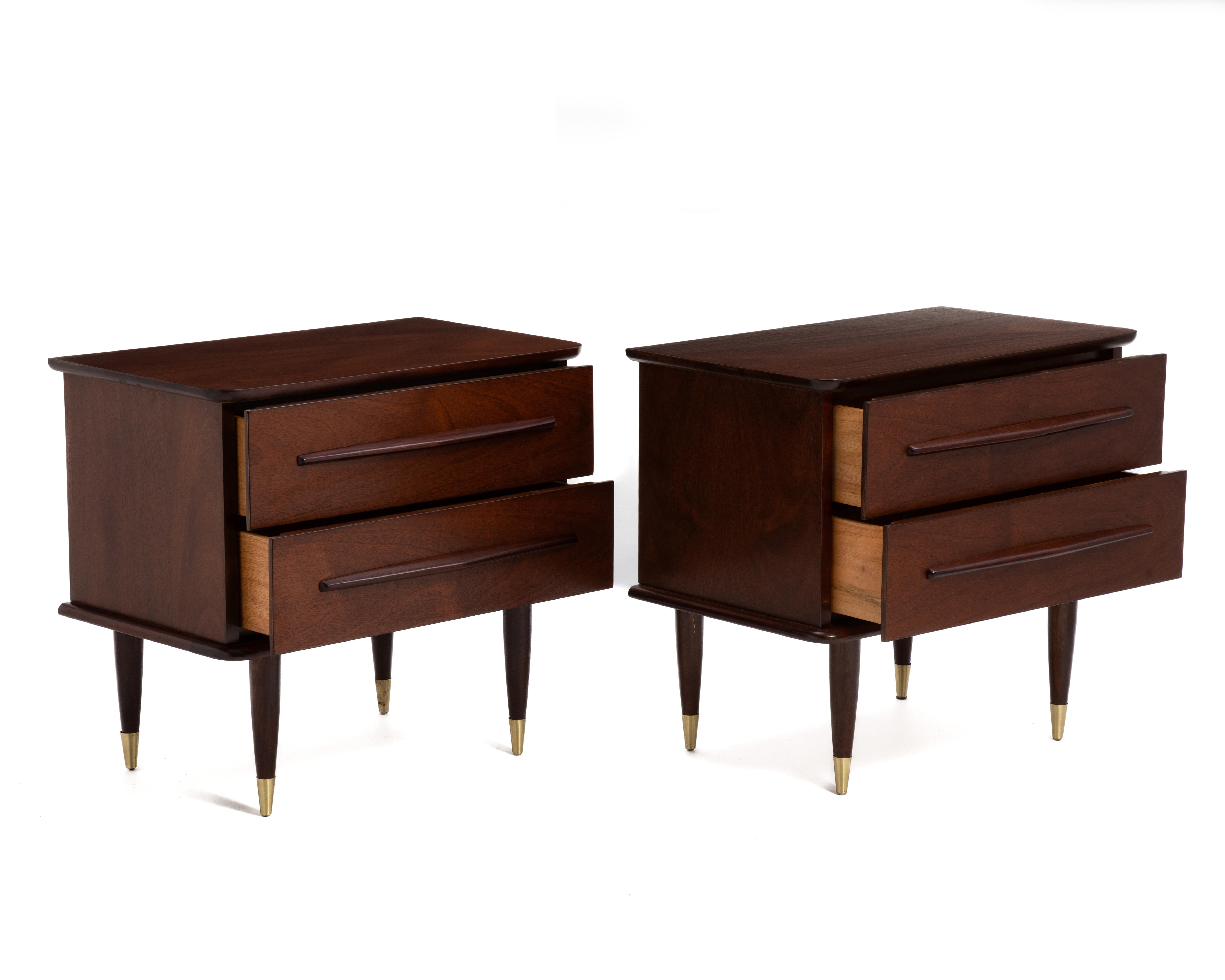 Una coppia di comodini Mid Century Furniture. Mogano con piedini in ottone. Maniglie ampie e scenografiche con tiretti nascosti e piani sporgenti. 