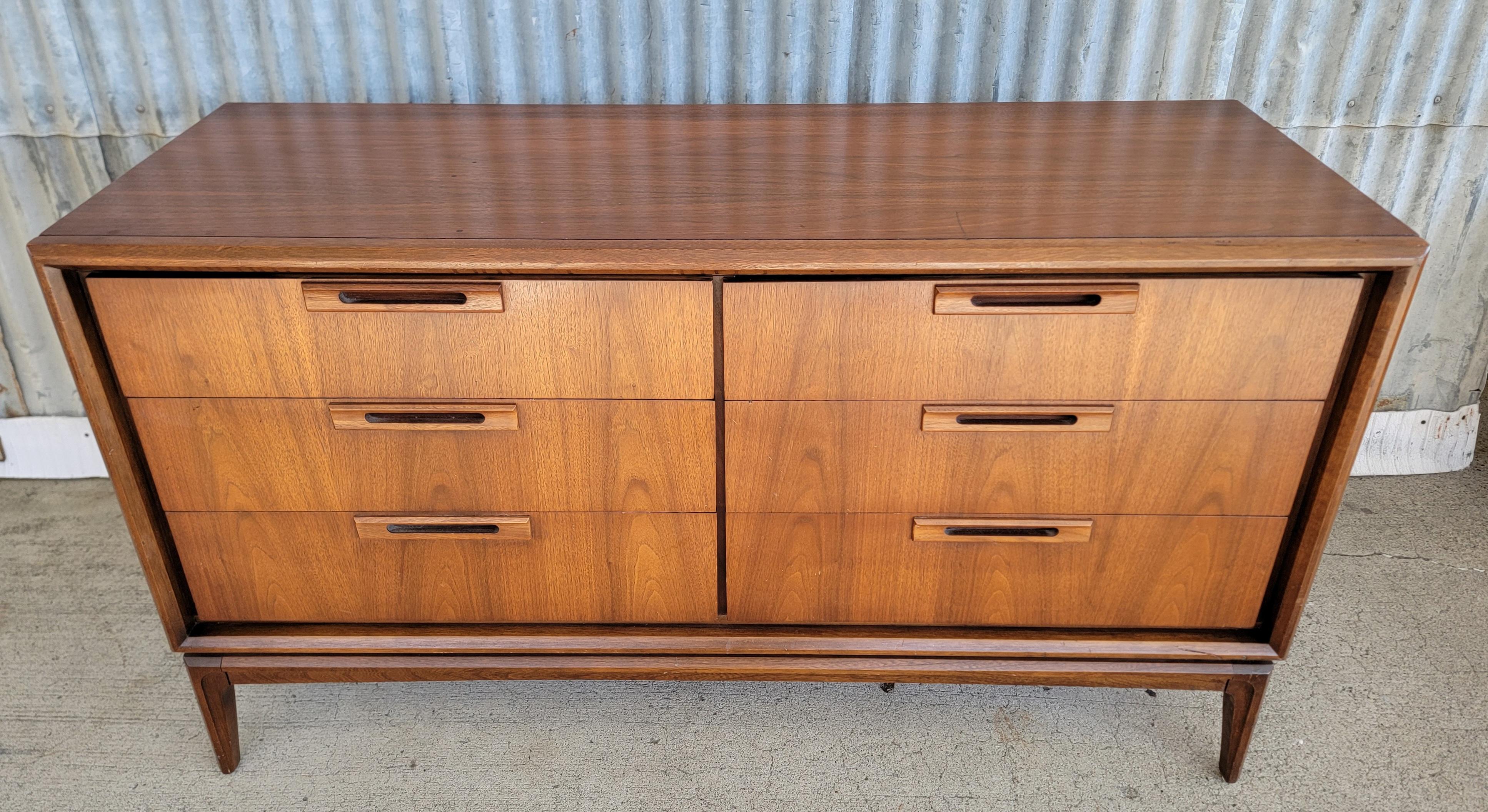 Une commode basse à six tiroirs en noyer par United Furniture Company, circa. 1950. Fabrication soignée avec des bois intérieurs en chêne massif et une construction à queue d'aronde. Dépoussiérer les panneaux entre les tiroirs et les glissières des