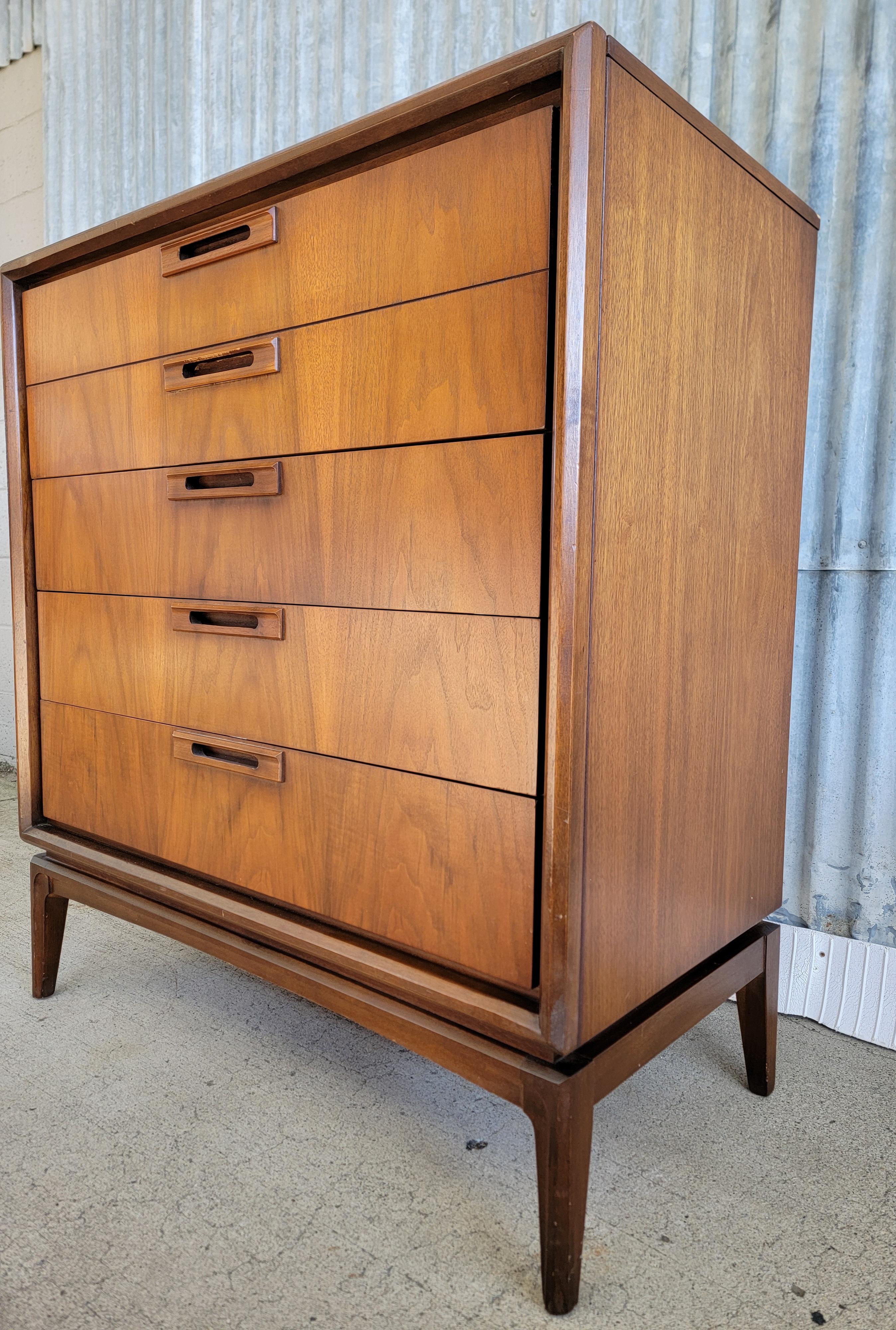 A walnut tall drawer low (highboy) dresser by United Furniture Company, circa. 1950. Fine craftsmanship with solid oak interior woods and dovetail construction. Dust panels between drawers and center drawer glide tracks. Very good original condition