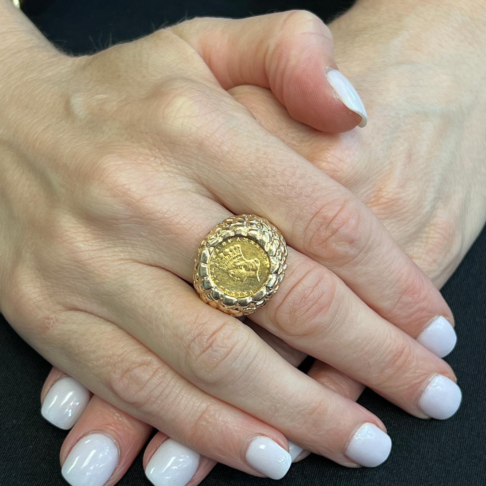 United States $1 gold coin ring circa 1874. The coin is set in a textured 14 karat yellow gold ring measuring approximately 20mm in width and currently size 6.5 (can be sized). 