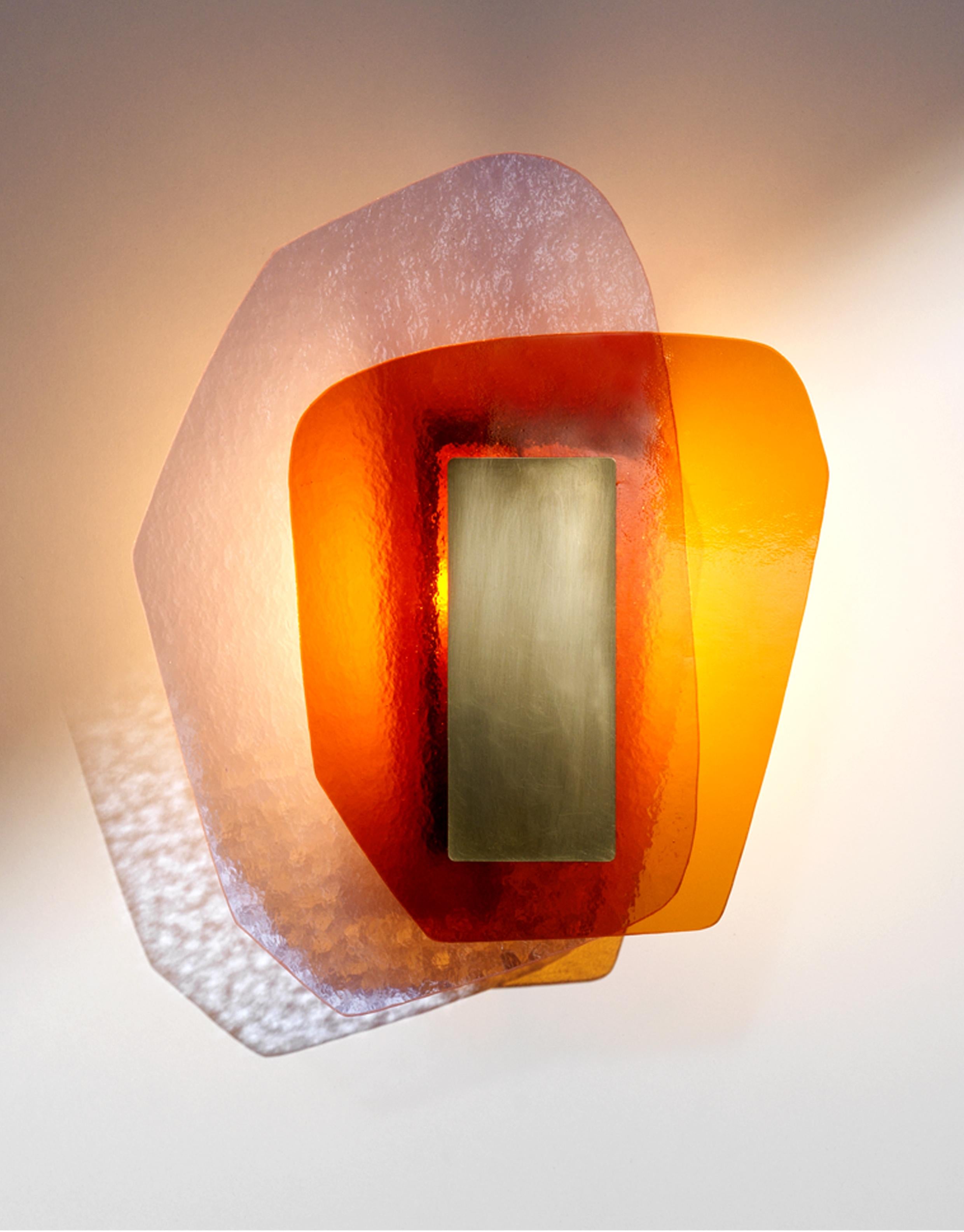 Unity light sculpture by Marie Jeunet
Dimensions: H 34 x L 26 cm
Materials: Lilac hammered glass sheet, smooth amber glass sheet, brushed brass structure and finish

Les Precieux
These luminous sculptures evolve with the rhythm of the passing