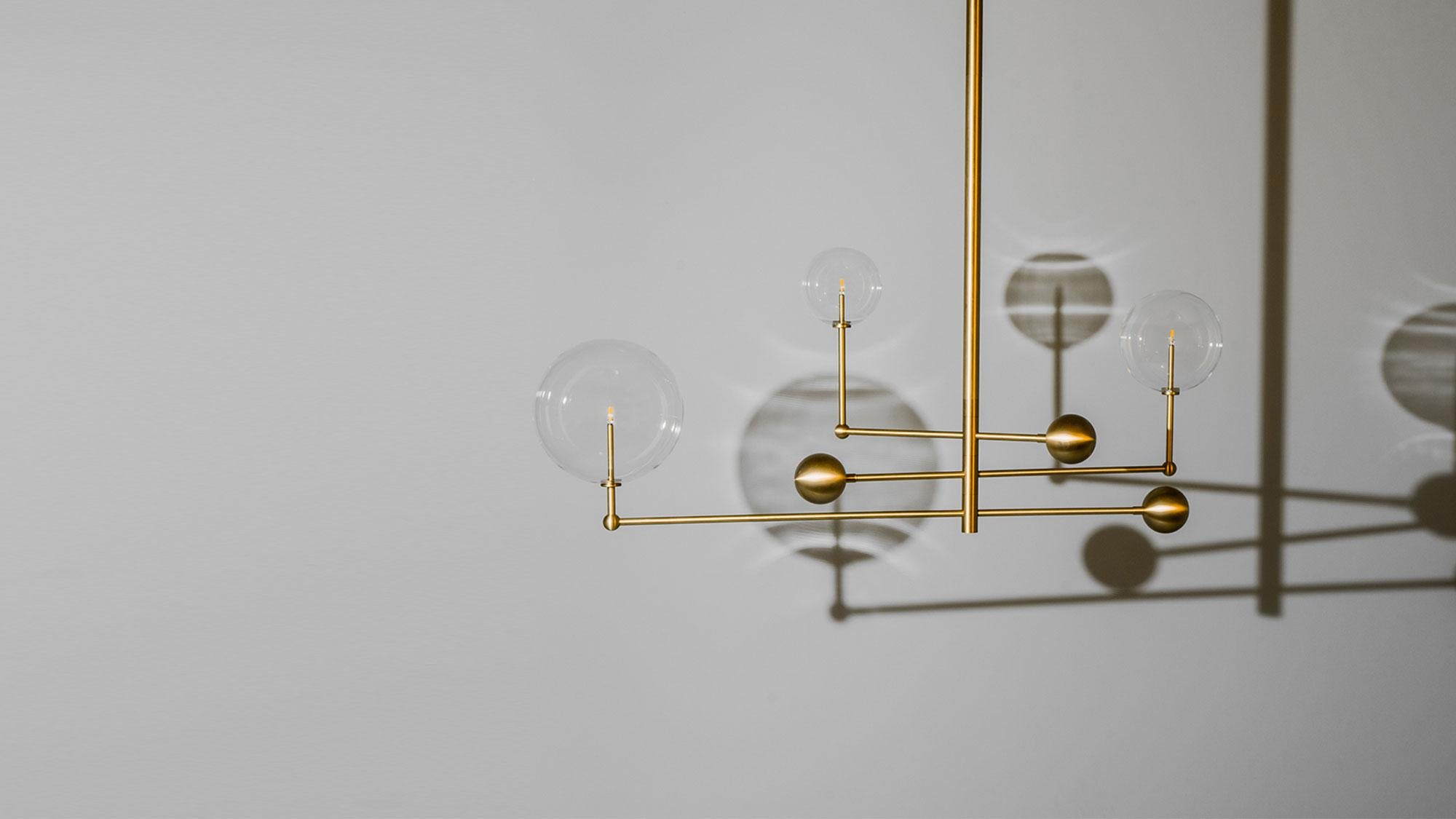 Three illuminated glass globes orbit a central gravitational axis. Rotating brass arms evoke the mechanical grace of the astronomical orrery. A celestial piece where precision meets elegance.

Available in our three signature finishes: Lacquered