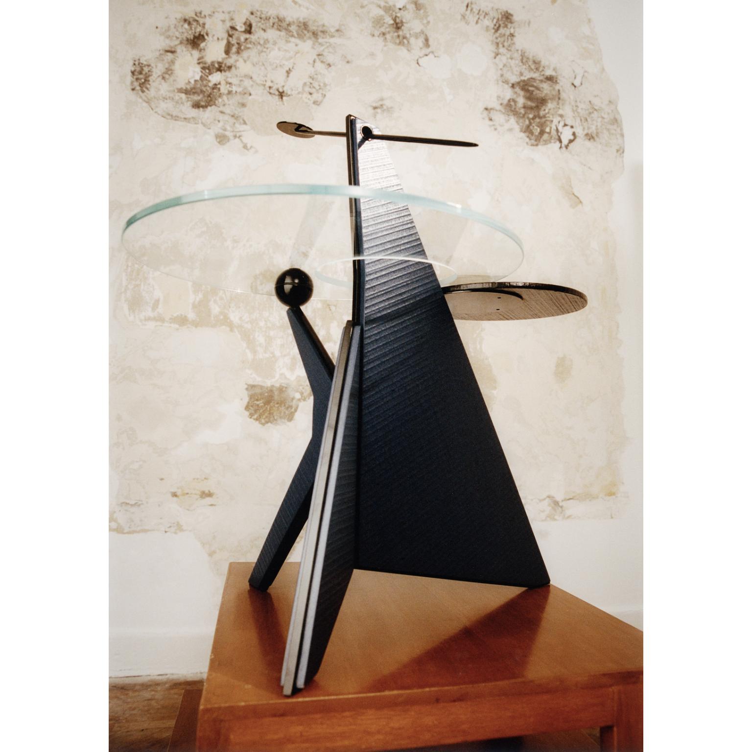 Table d'appoint Universe en métal, laiton, verre trempé et Wood Wood bleu par Artempo
Dimensions : D 75 x L 75 x H 79,6 cm.
Matériaux : Métal, laiton, bois et verre trempé.

Les chandeliers interpénétrés s'étendent à l'infini, leurs terminaisons